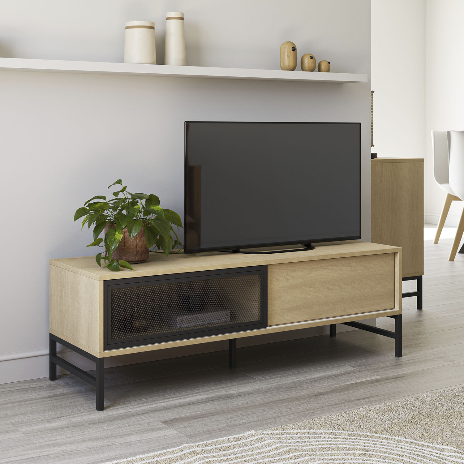 Un mueble de TV de madera con marco de metal negro, una planta en maceta y un televisor.