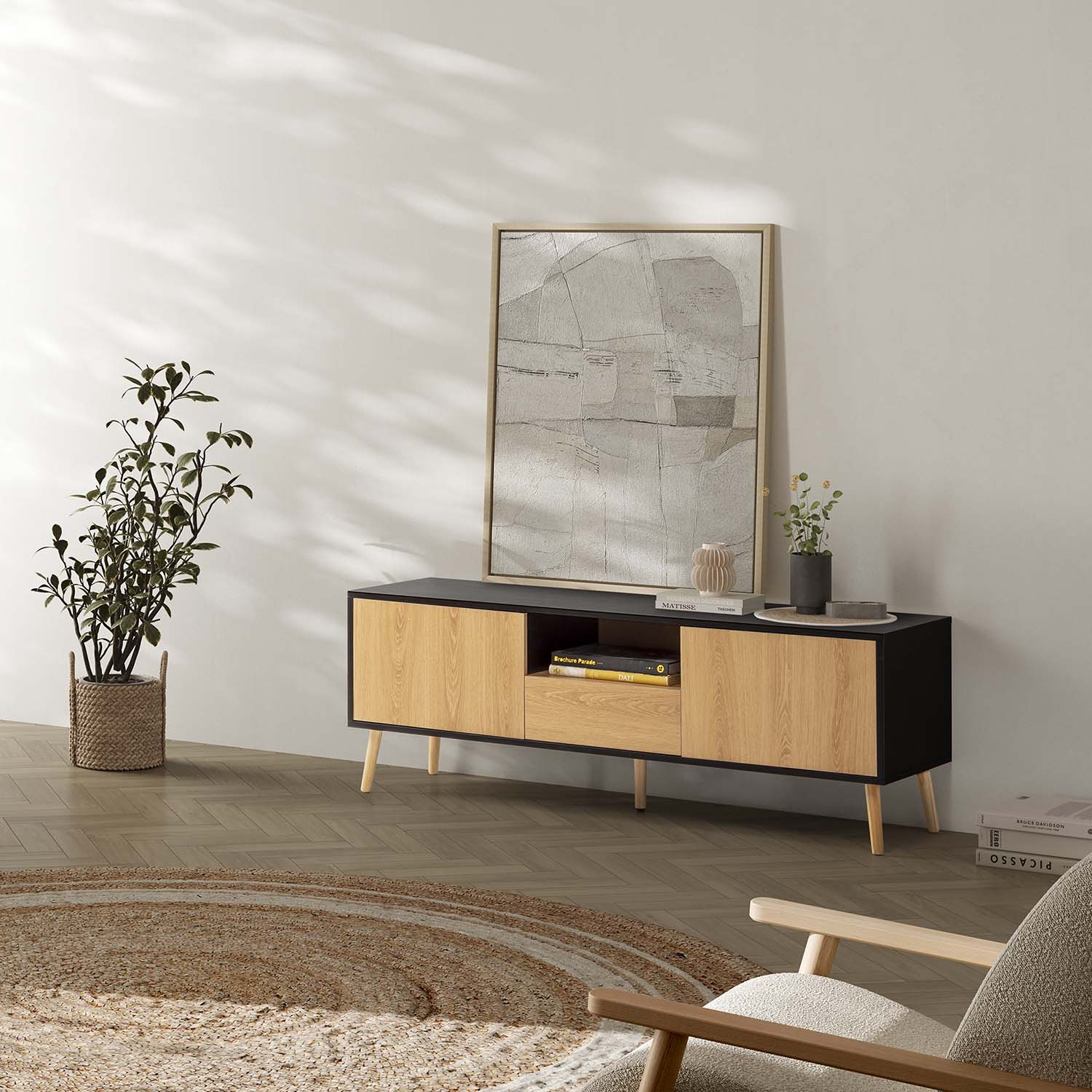 Un mueble de TV con detalles de madera, arte y planta en una sala moderna.