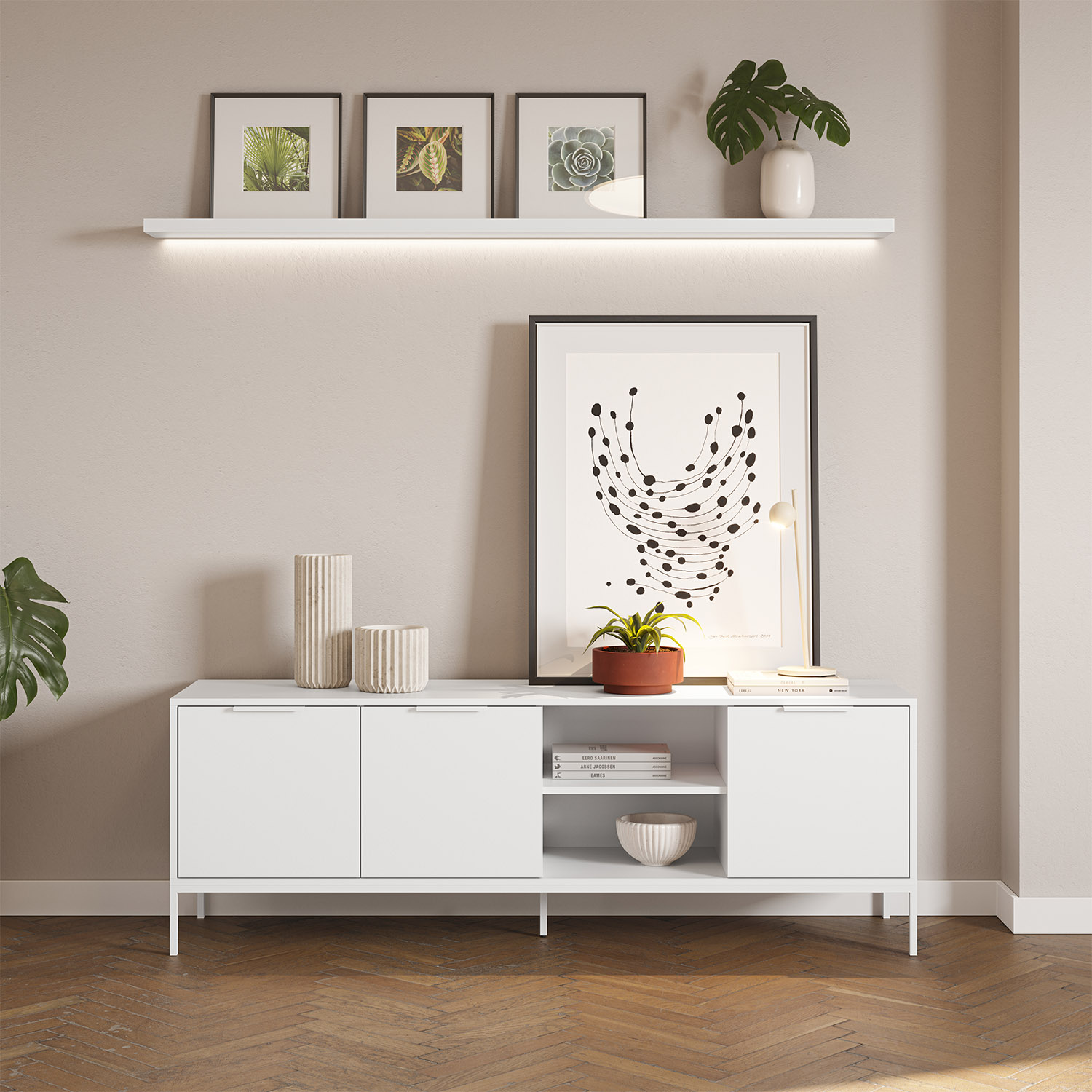 Un aparador blanco con decoraciones, cuadros enmarcados y plantas.