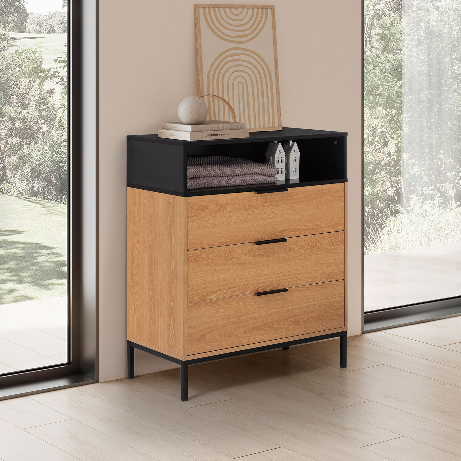 Cómoda moderna con cajones de madera y parte superior negra junto a una ventana.