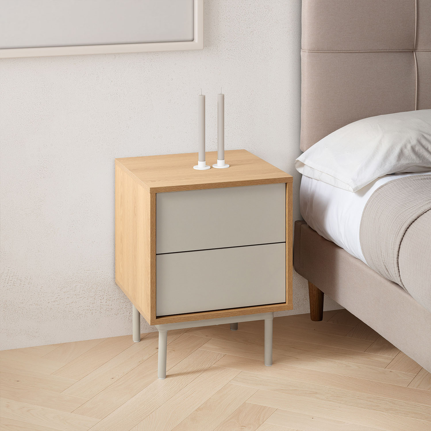 Una mesita de noche de madera con cajones grises junto a una cama.