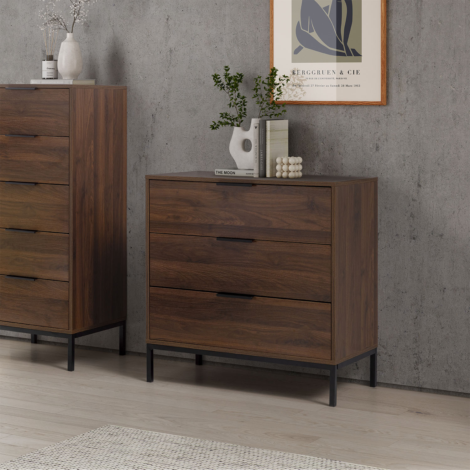 Dos cómodas de madera oscura con patas negras frente a pared de hormigón, arte arriba.