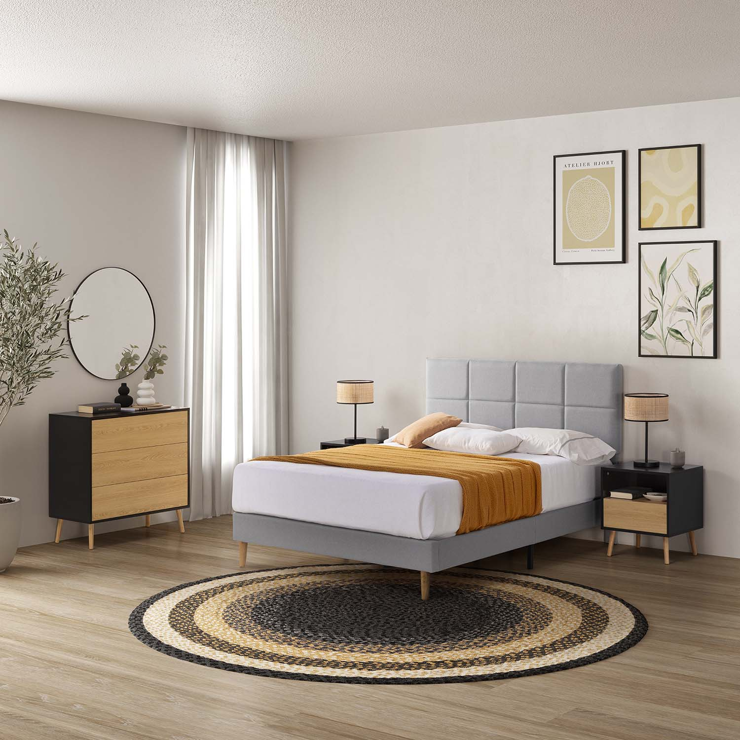 Un dormitorio con cama gris, mesitas de noche, alfombra redonda y arte en la pared.