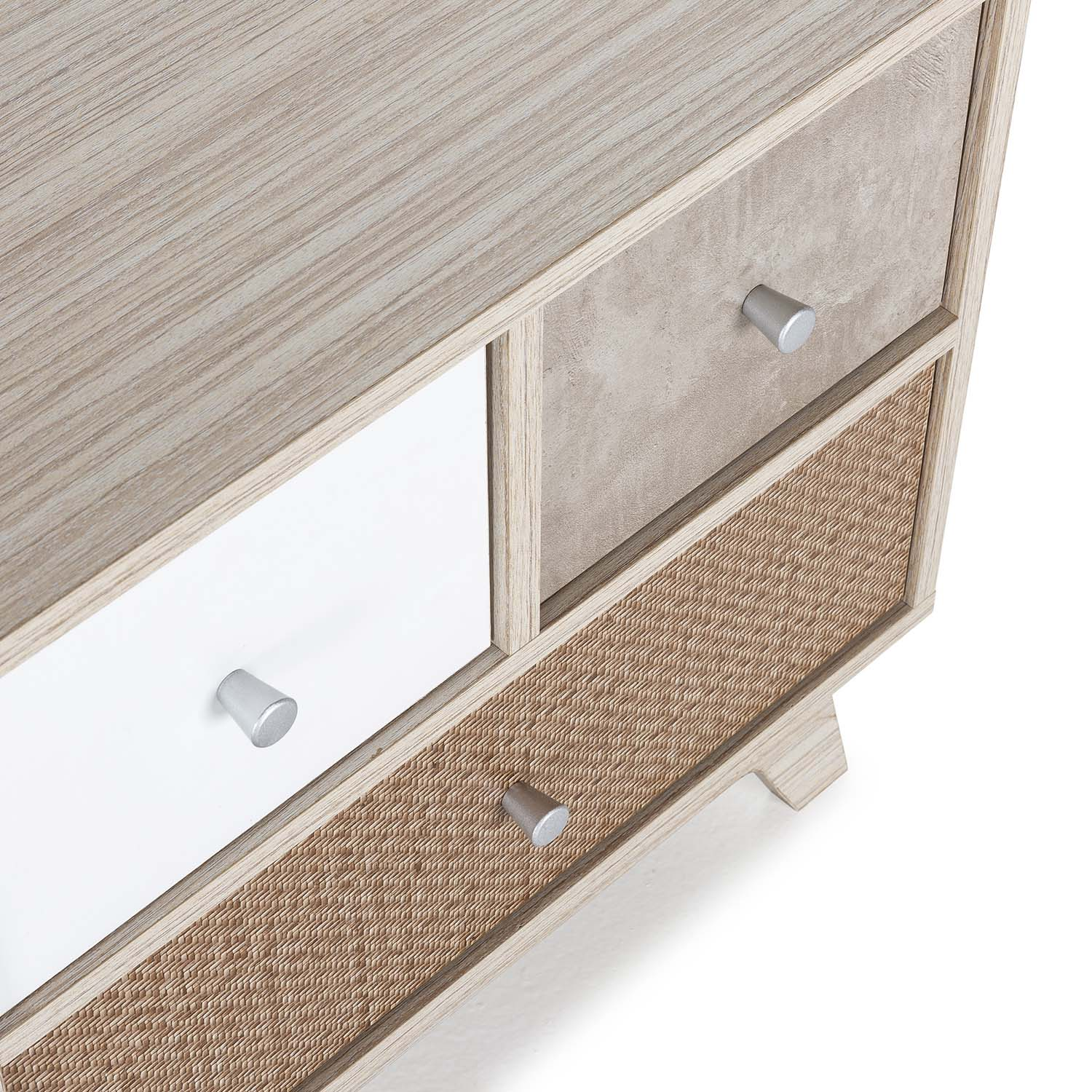 Primer plano de una cómoda con vetas de madera, cajones blancos, beige y tejidos.