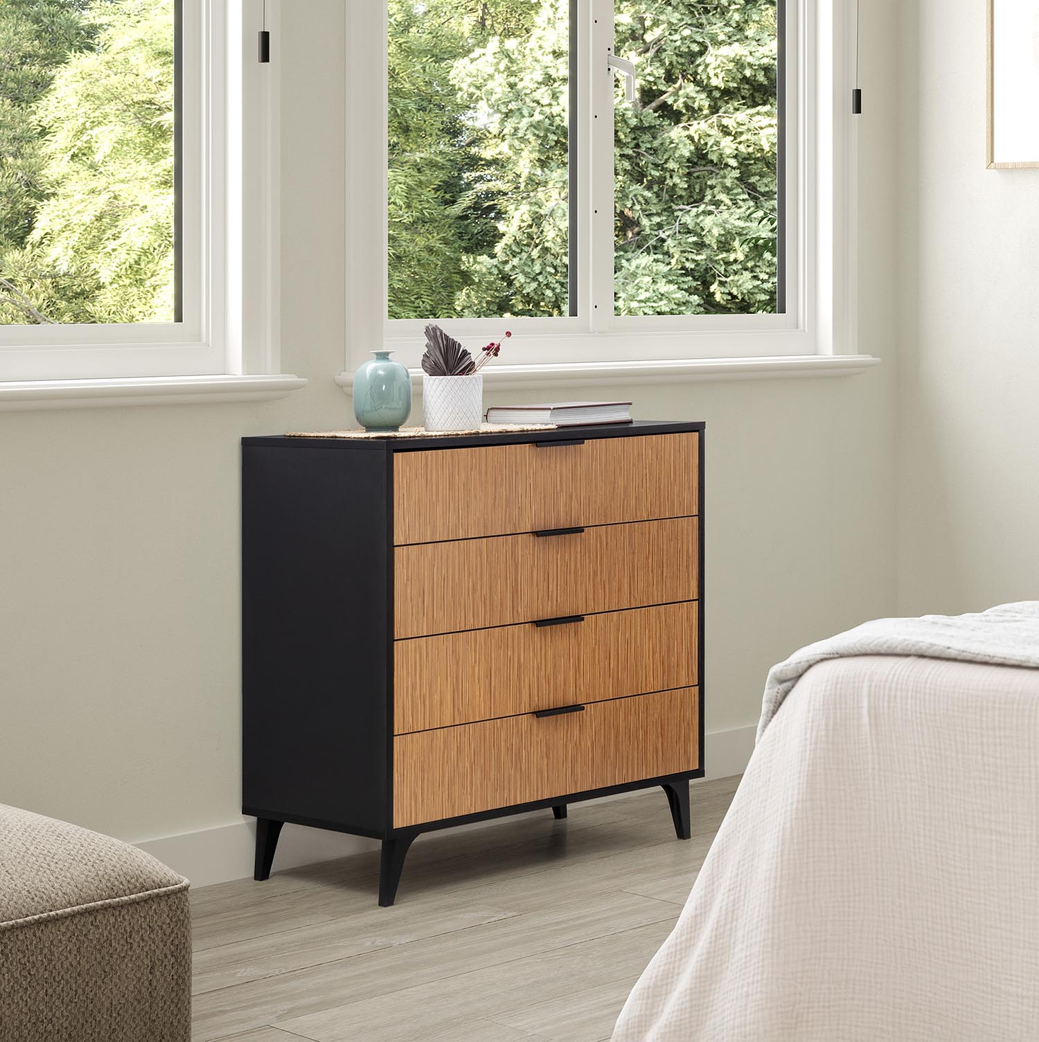 Cómoda moderna con cajones de madera junto a una cama, ventana al fondo.