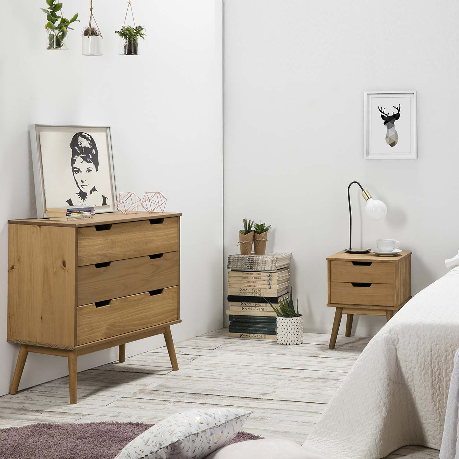 Un dormitorio con muebles de madera, plantas, arte de Audrey Hepburn y decoración de ciervo.