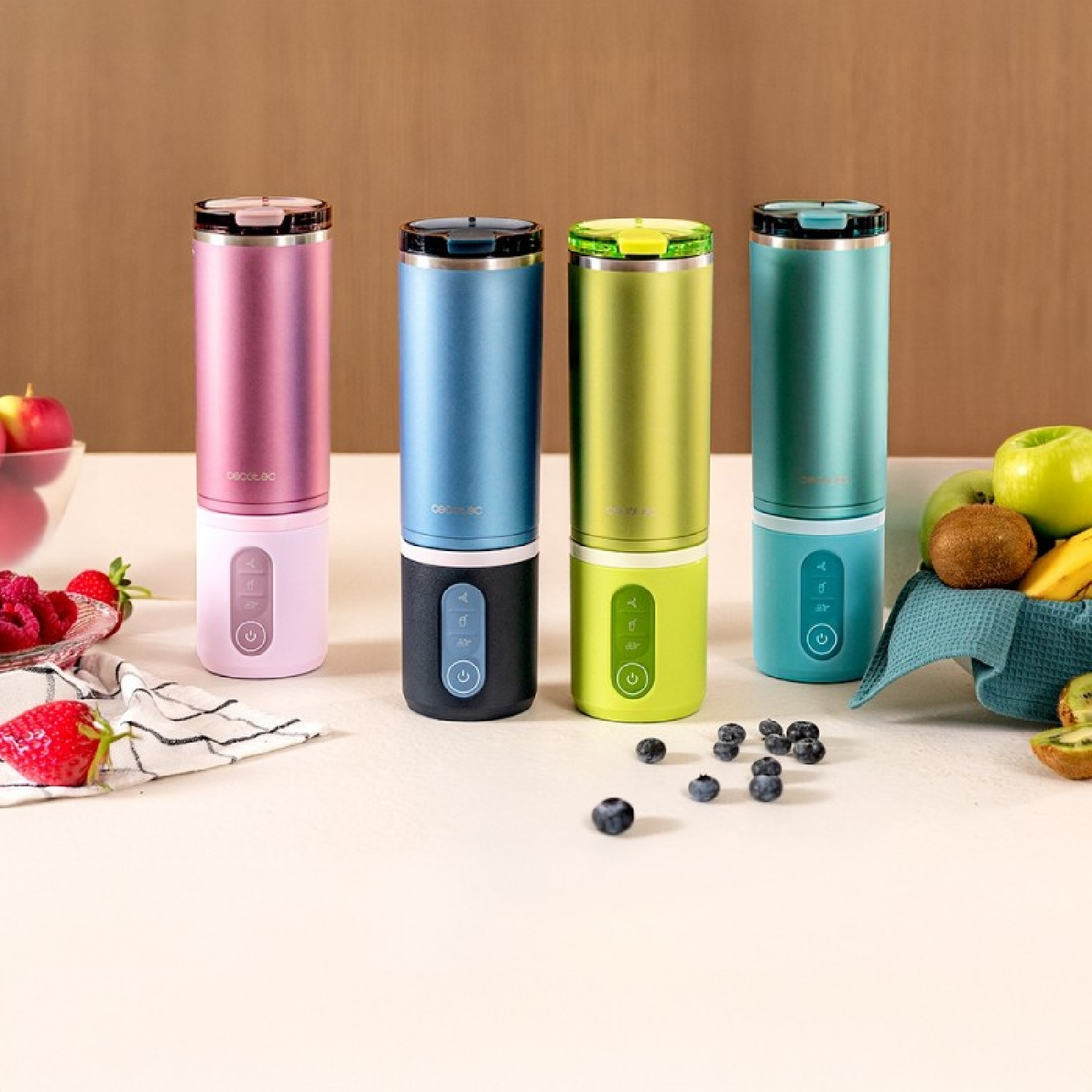 Cuatro licuadoras portátiles en rosa, azul, verde y turquesa con frutas.