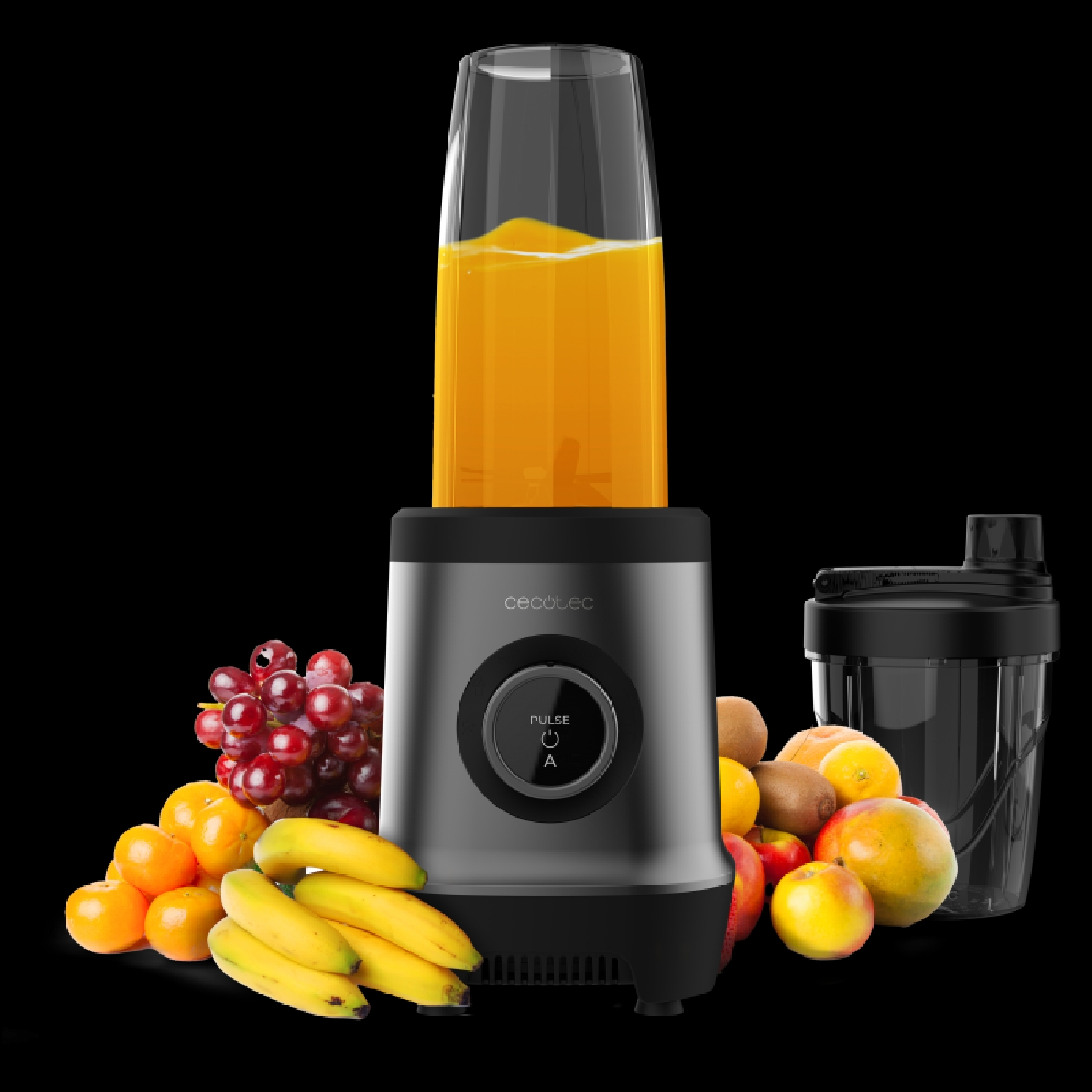 Una licuadora con un vaso de jugo de naranja, rodeada de frutas como plátanos, uvas, kiwis y naranjas.