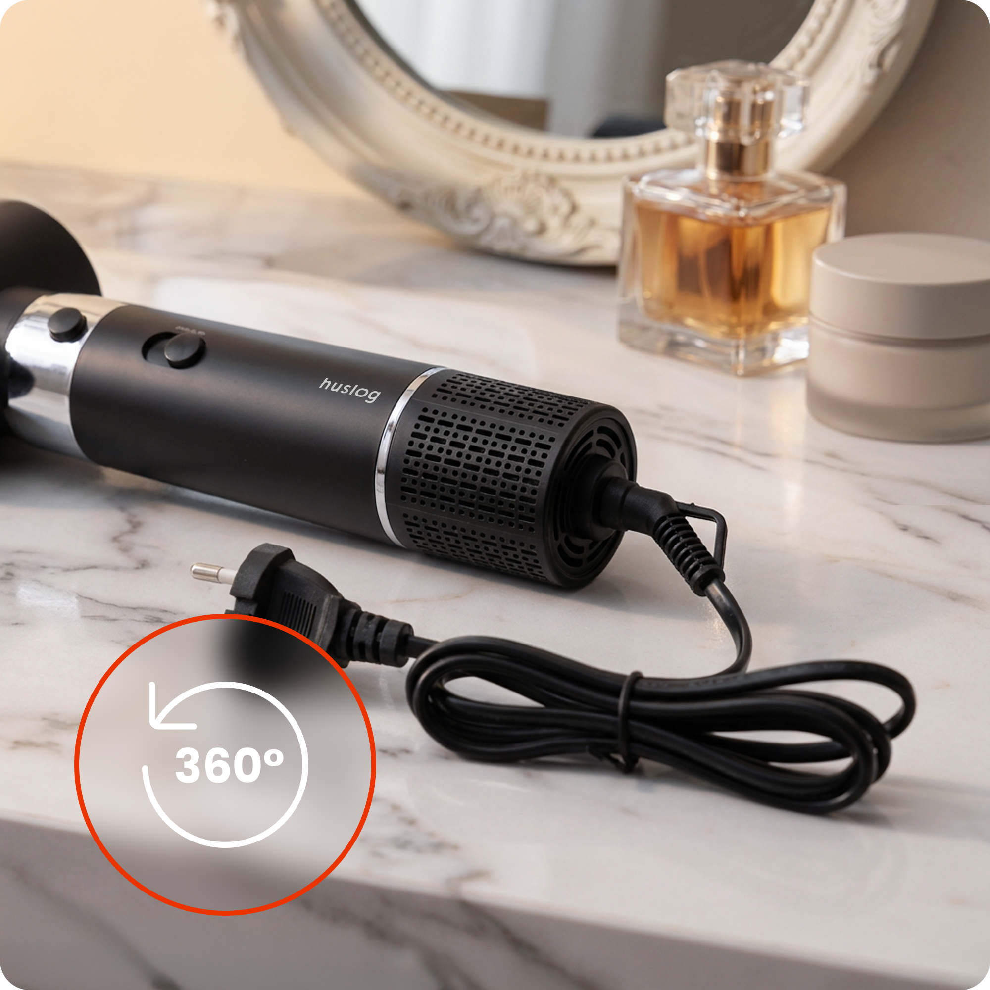 Czarna suszarka do włosów z kablem na marmurowym stole, obok perfum i kremu.