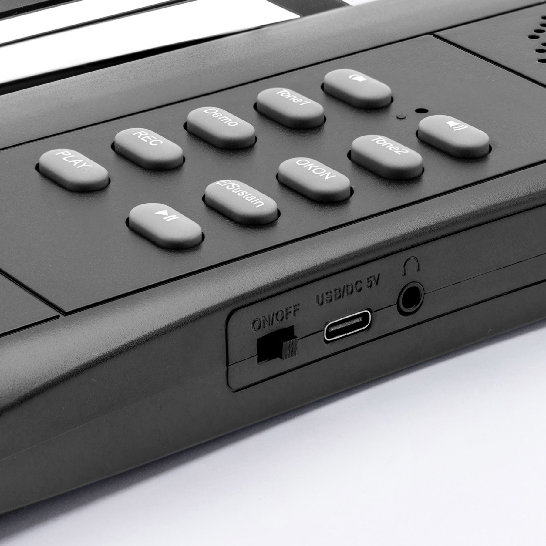Zbliżenie czarnej klawiatury z szarymi przyciskami: PLAY, REC, DEMO, SUSTAIN, OKON, TONE1, TONE2.