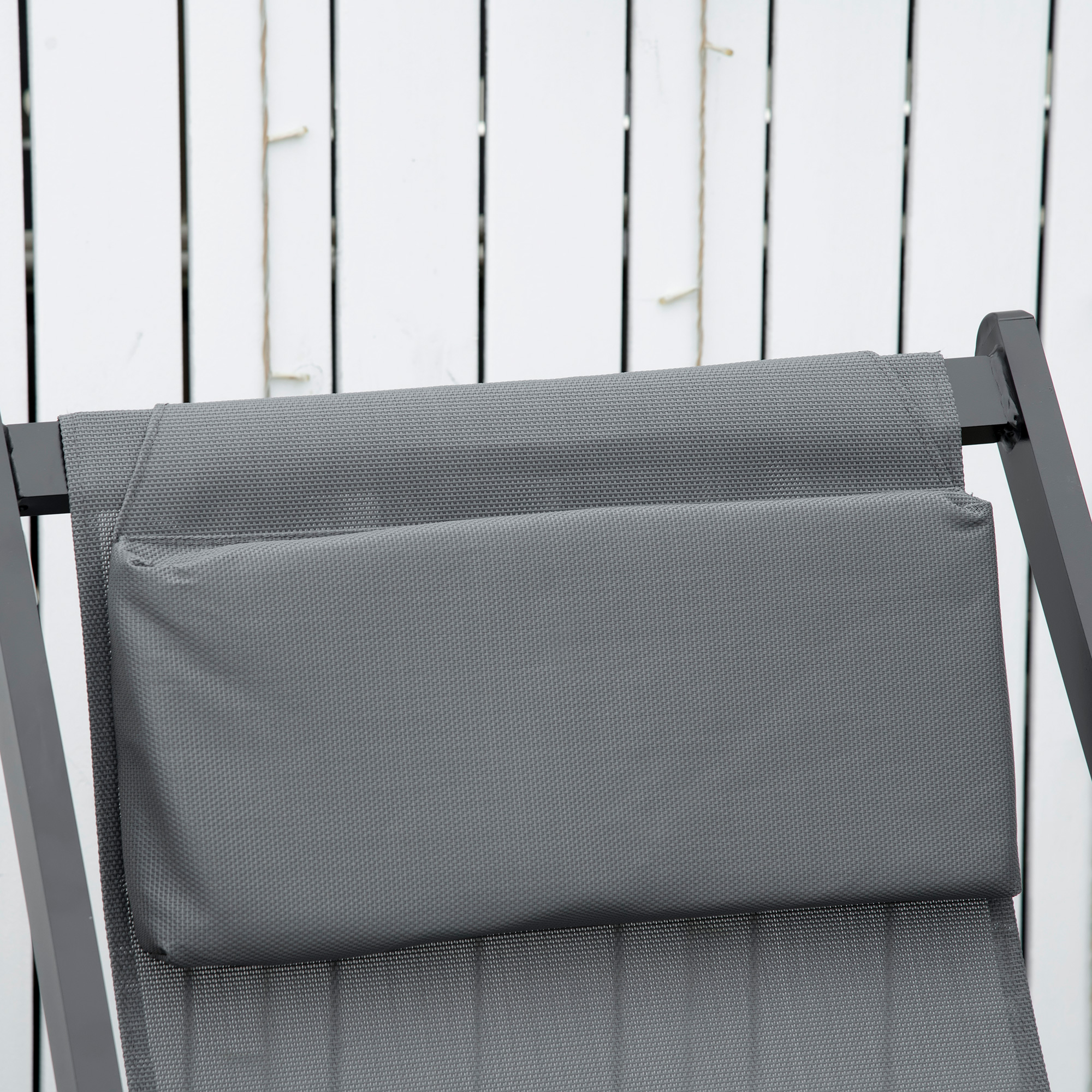 Cojín gris sobre una silla con fondo blanco.