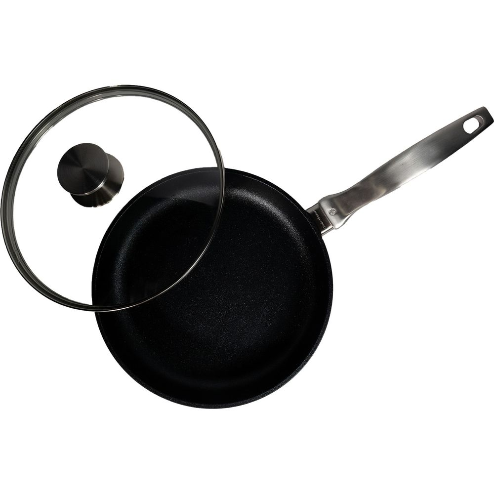 Poêle noire avec couvercle en verre et manche en acier inoxydable.