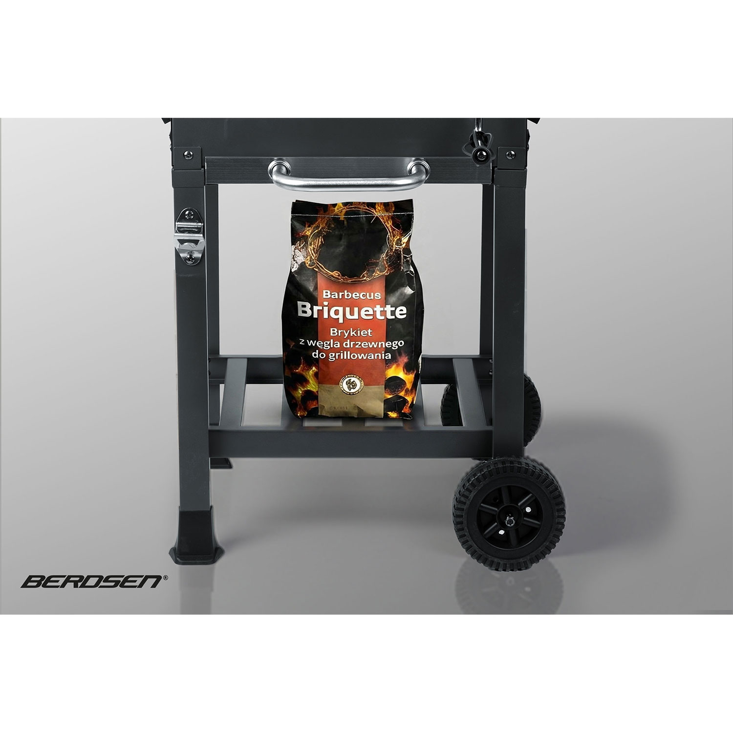 Czarny grill z workiem brykietu węgla drzewnego na dolnej półce.