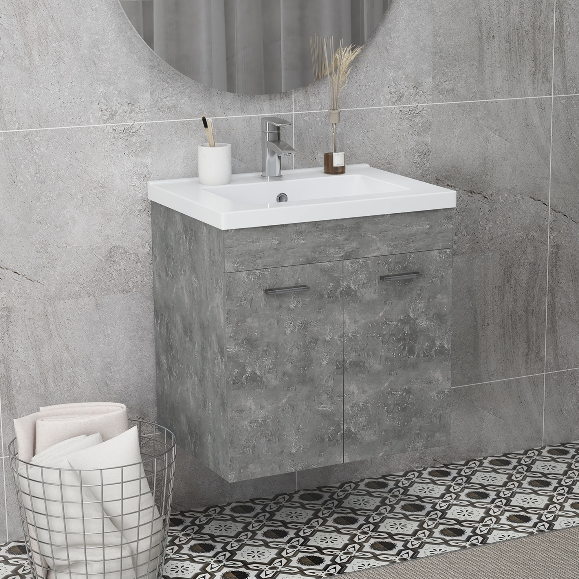 Baño moderno con mueble de lavabo efecto hormigón, lavabo blanco y espejo redondo.