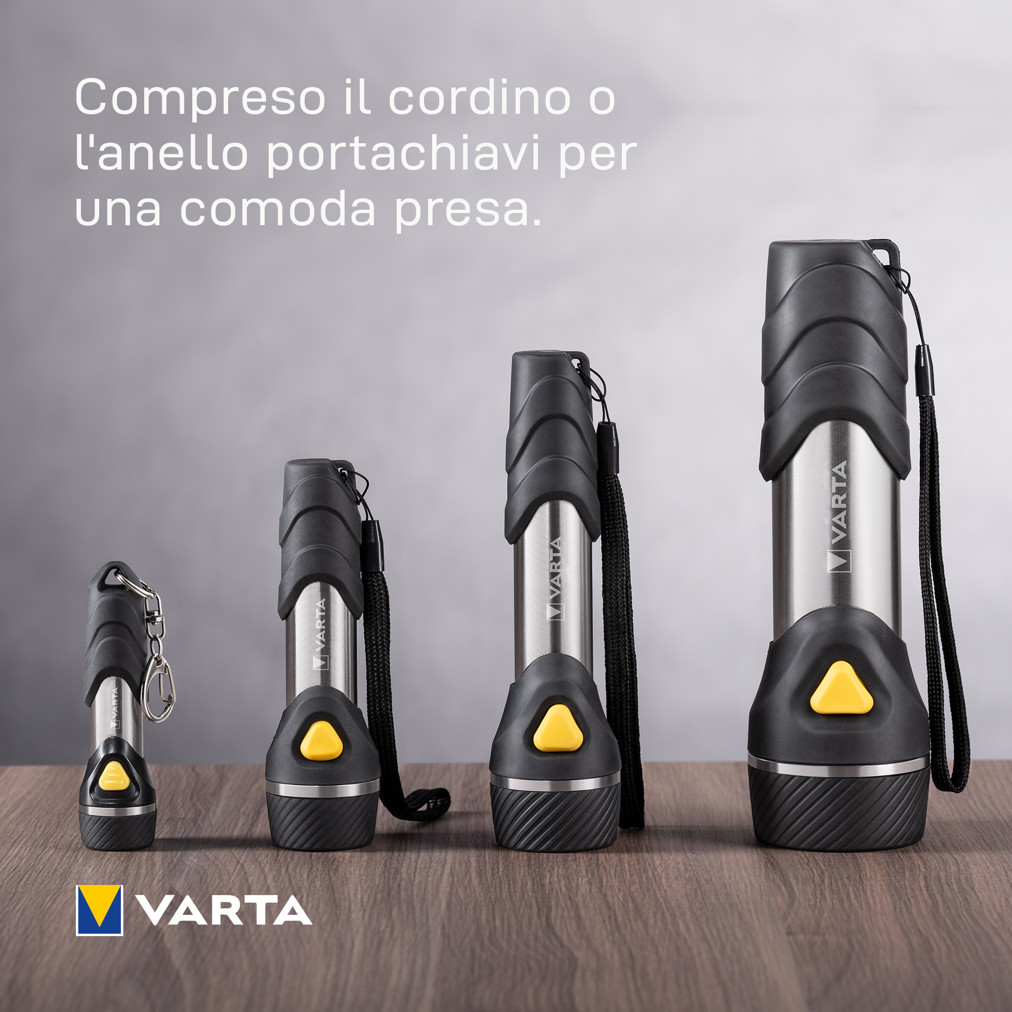 Quatre lampes de poche Varta de différentes tailles sur une table en bois.