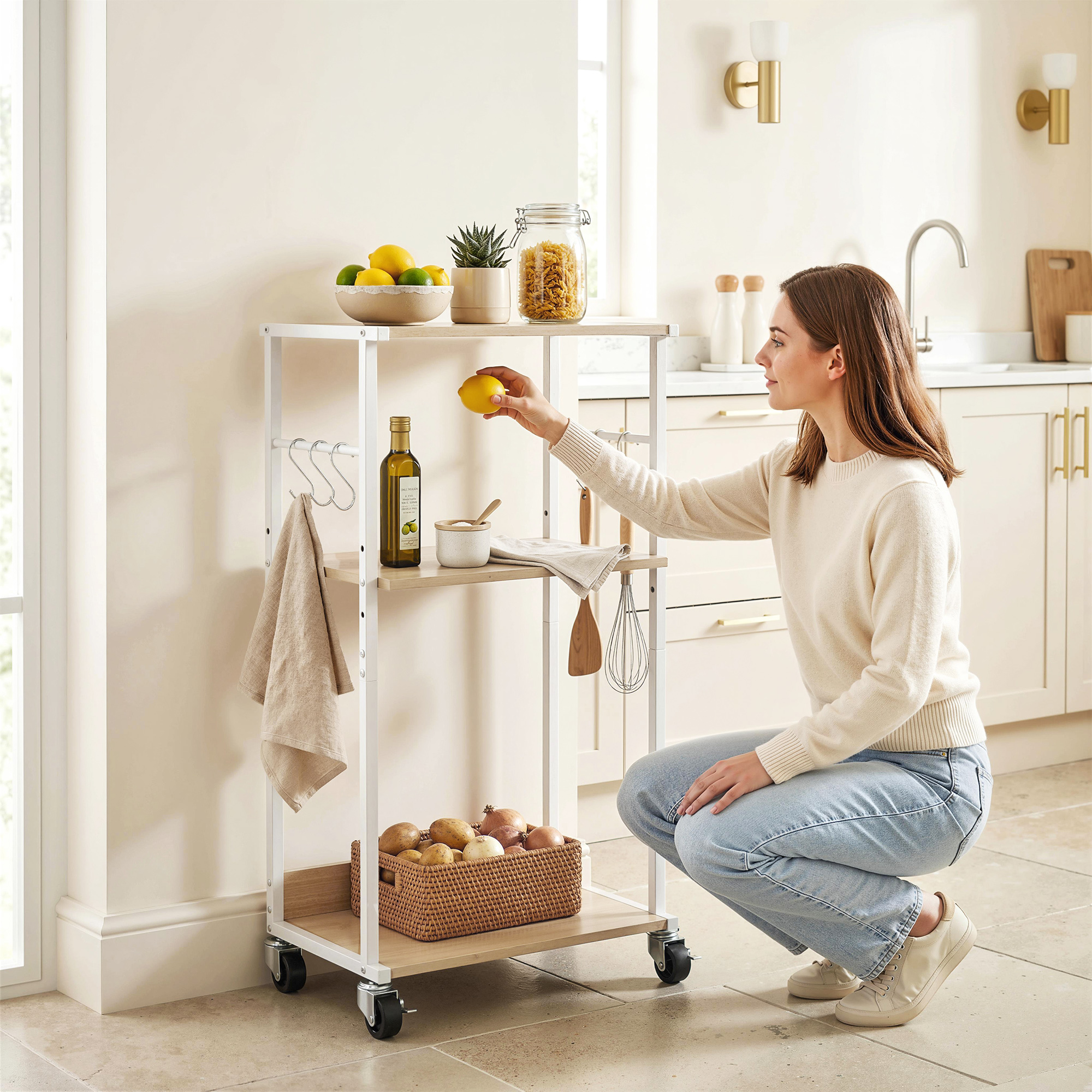 Mujer coge limón en carrito de cocina con fruta, pasta y verduras.