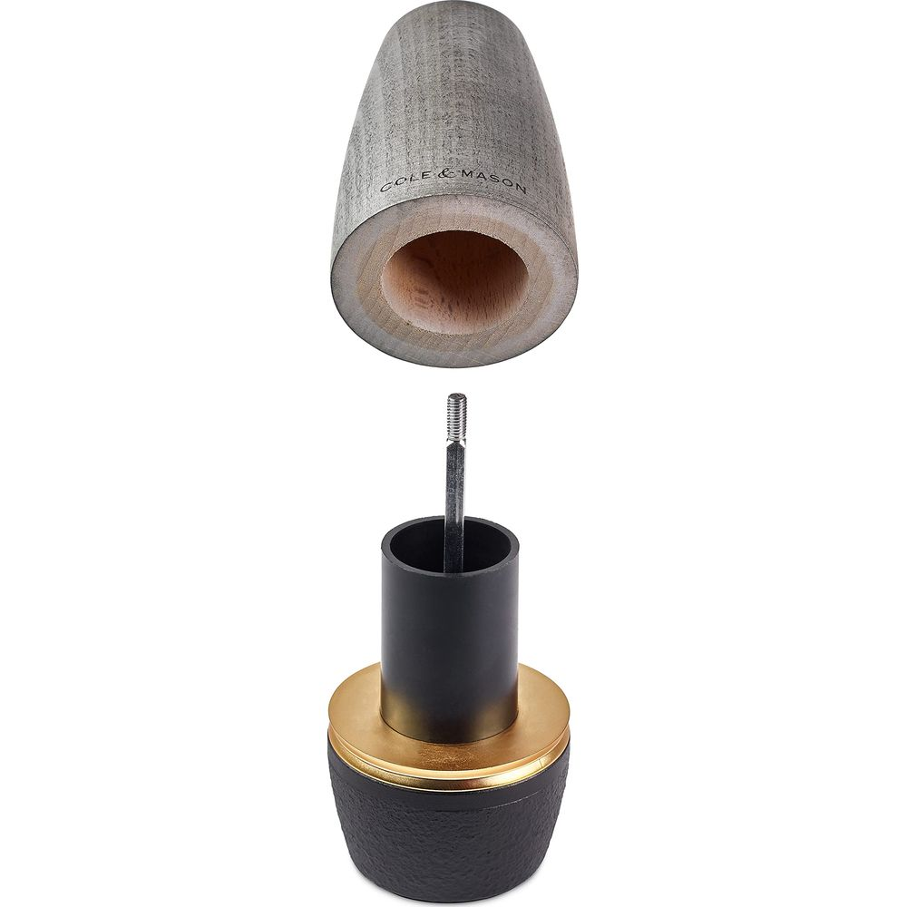 Nahaufnahme einer demontierten Holzpfeffermühle mit Metallteilen.