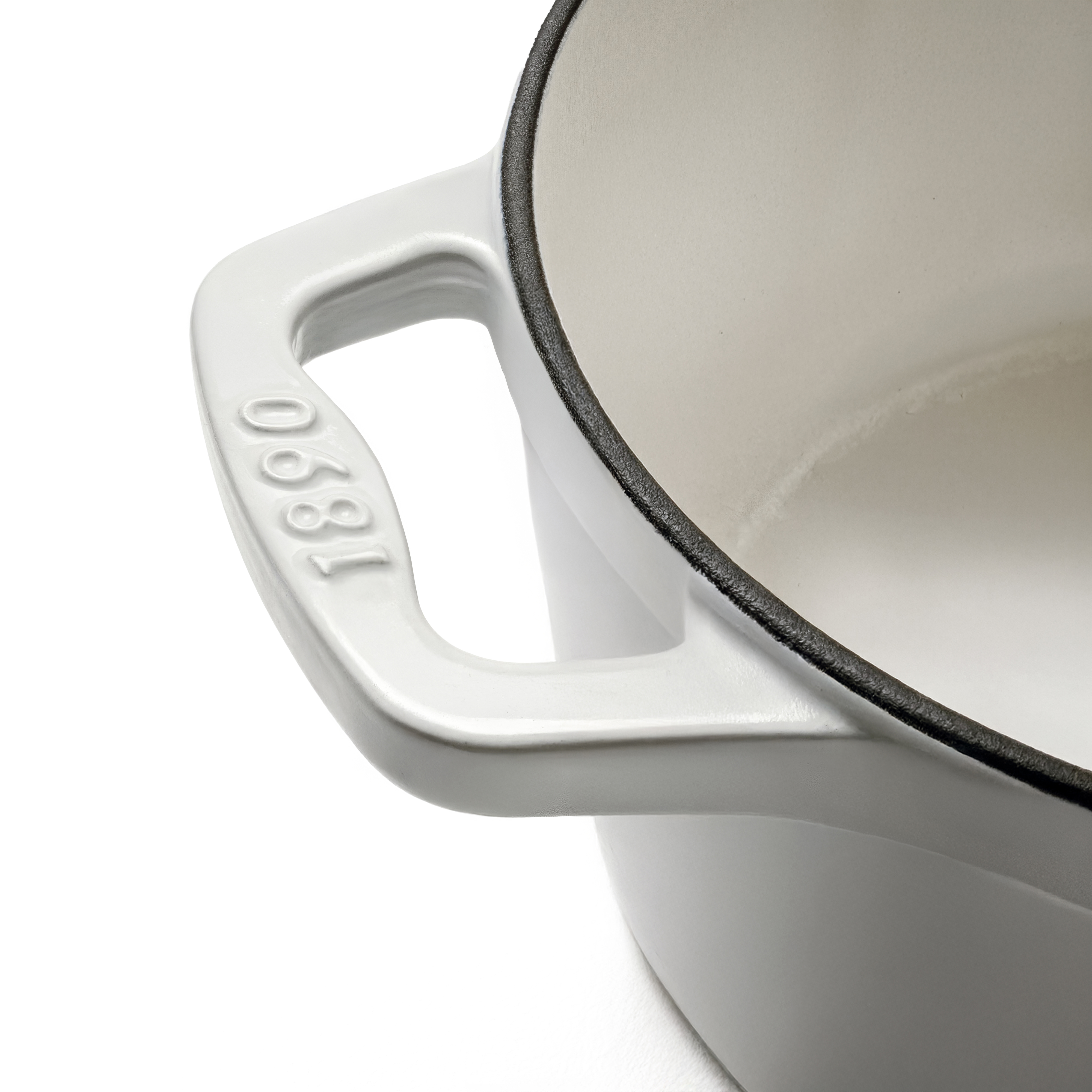 Una olla de hierro fundido blanca con borde negro y año grabado en el asa.