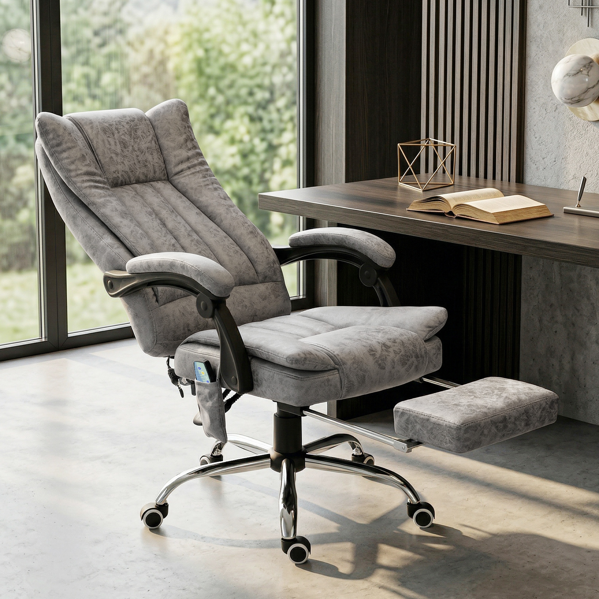 Silla de oficina gris con reposapiés extraíble frente a una ventana.