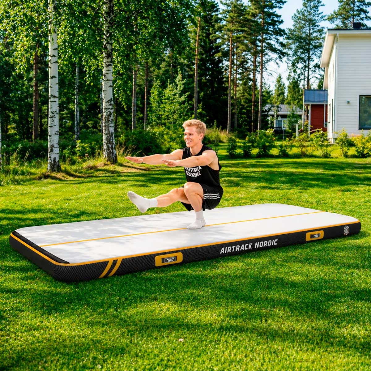 Mann in schwarzem Tanktop und Shorts macht einen Squat auf einer AIRTRACK NORDIC Matte.