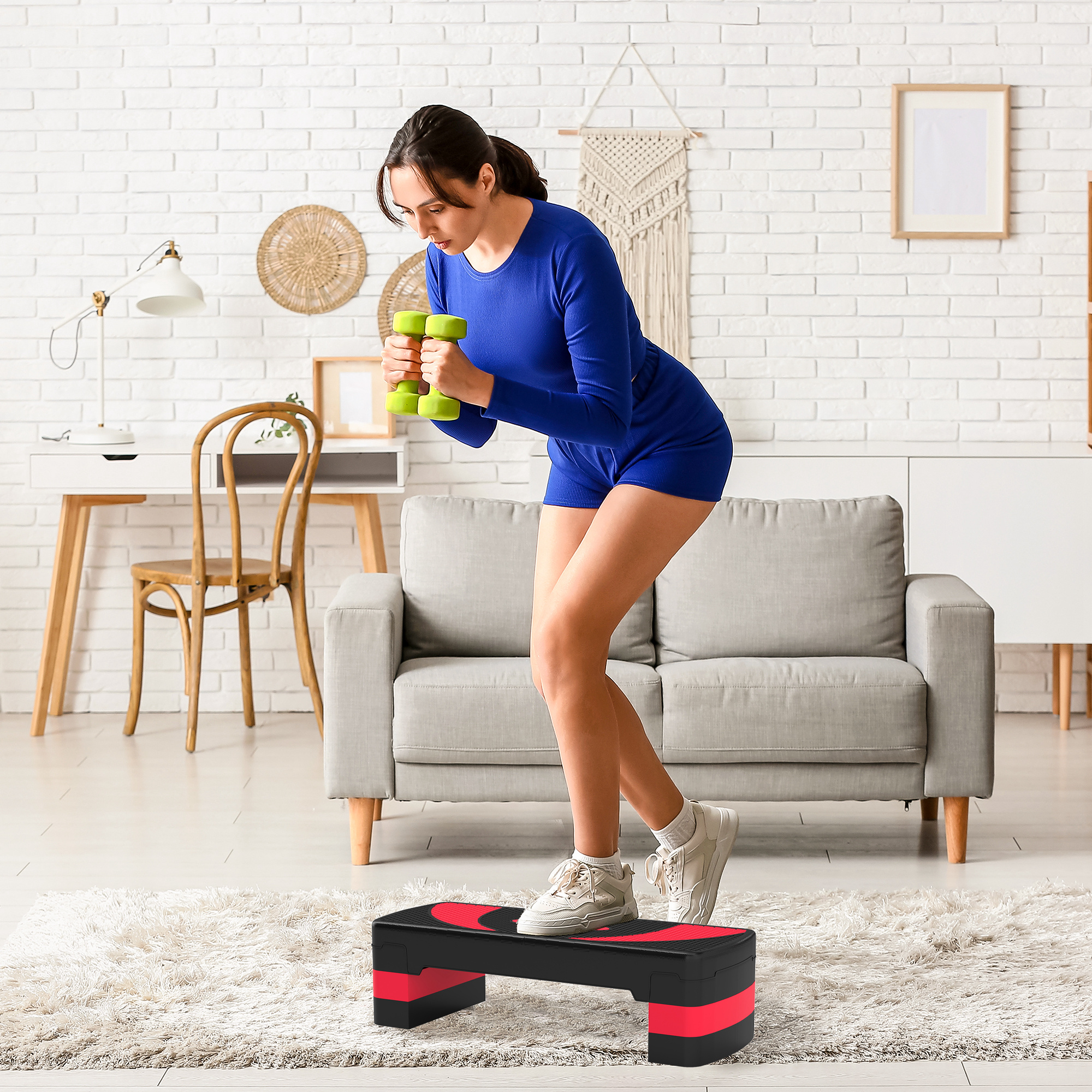 Una mujer con moño se ejercita con mancuernas en un step aeróbico en una sala de estar.