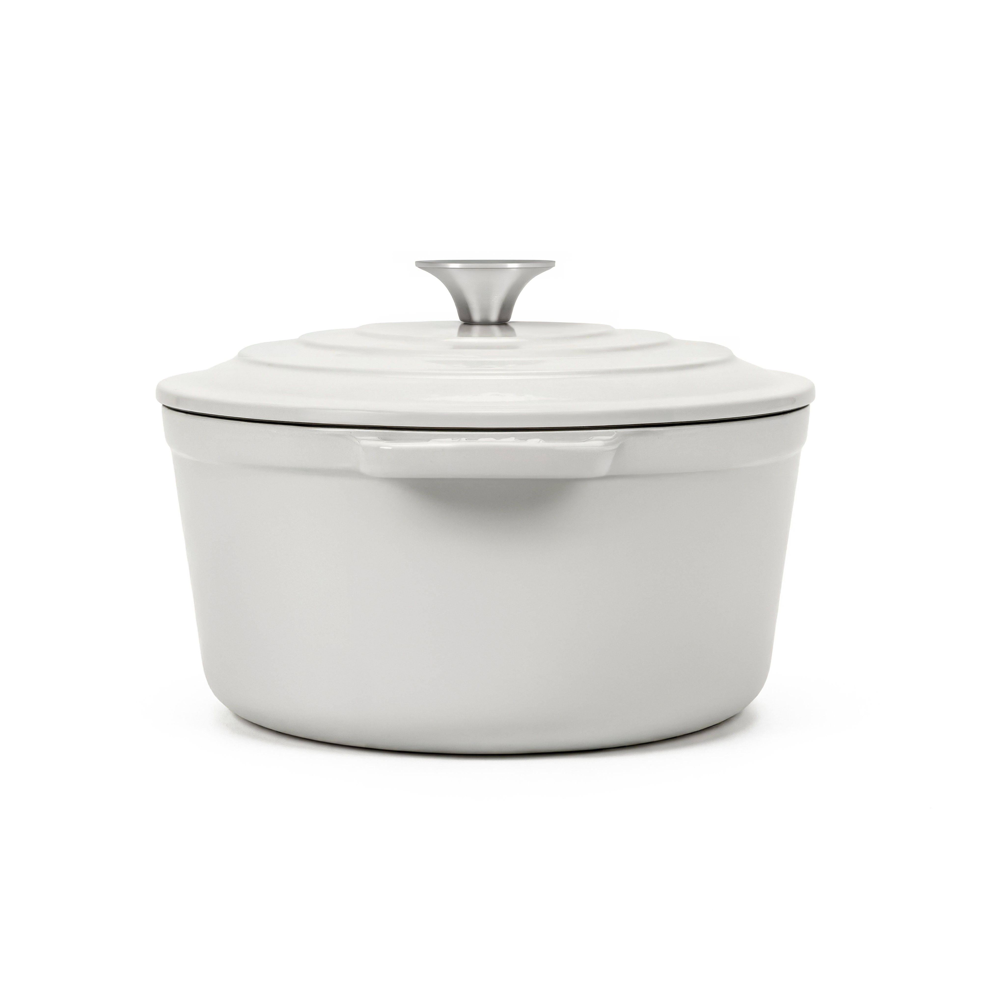 Una olla de hierro fundido blanca con pomo plateado sobre fondo blanco.