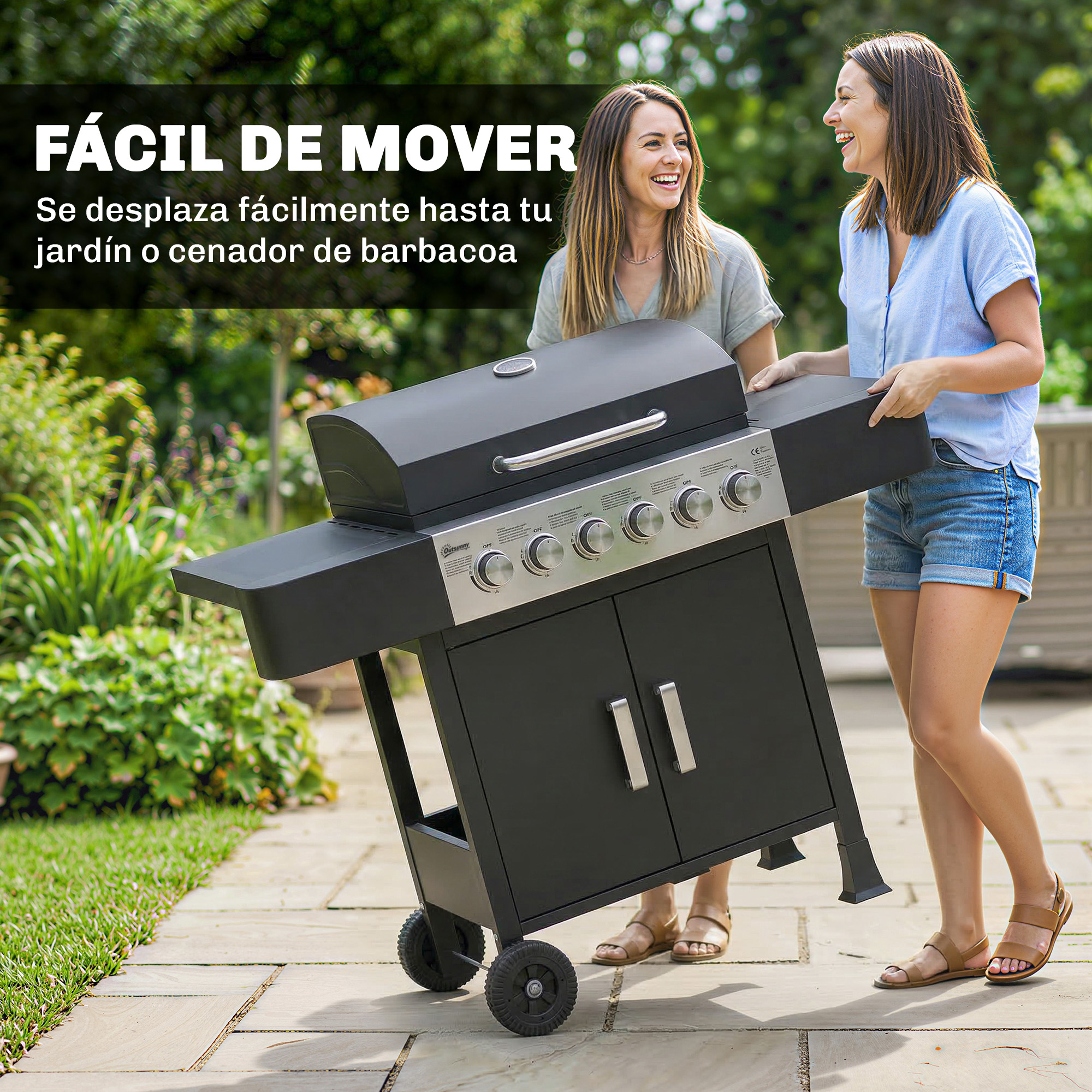Dos mujeres mueven una parrilla de gas negra por un patio de piedra en un jardín.