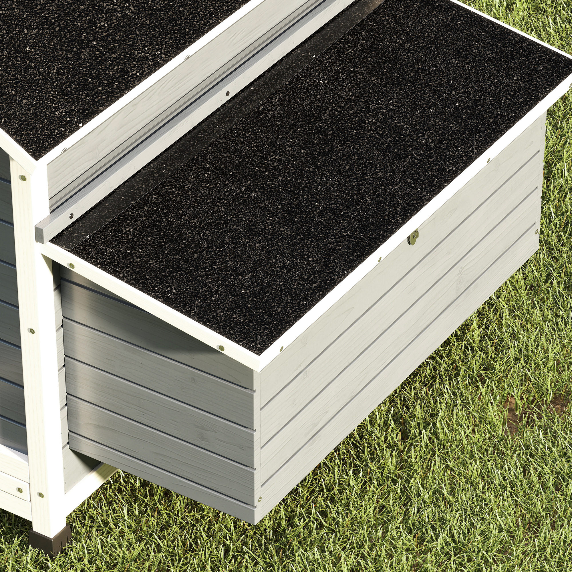 Una casa de madera gris con techo negro sobre hierba verde.