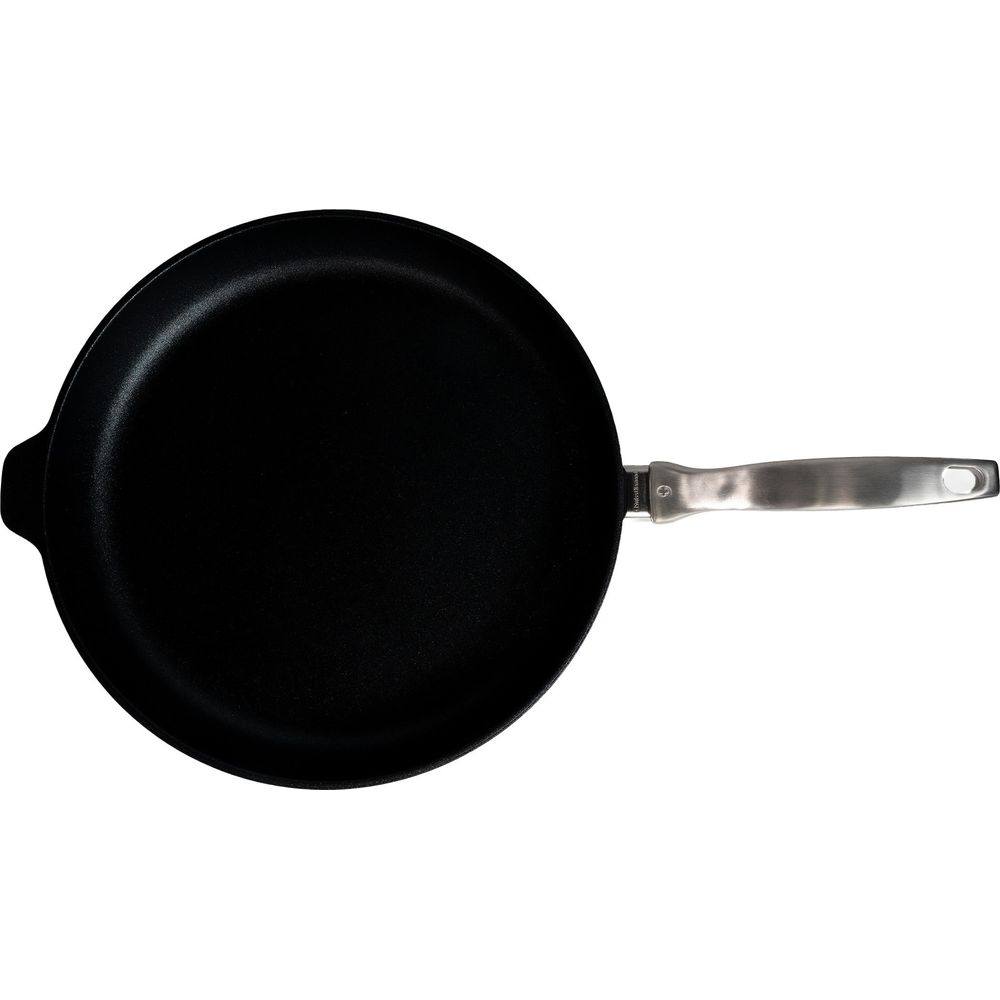 Poêle noire avec un long manche argenté sur fond blanc.