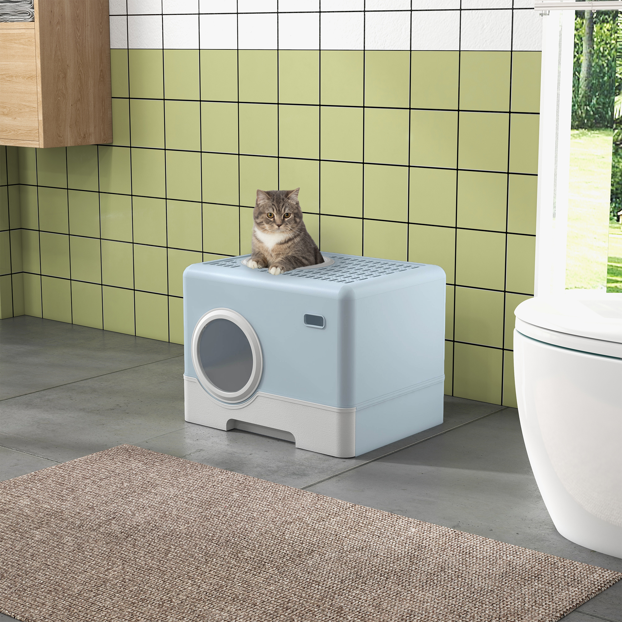 Un gato se sienta en una caja de arena azul claro en un baño con azulejos verdes y blancos.