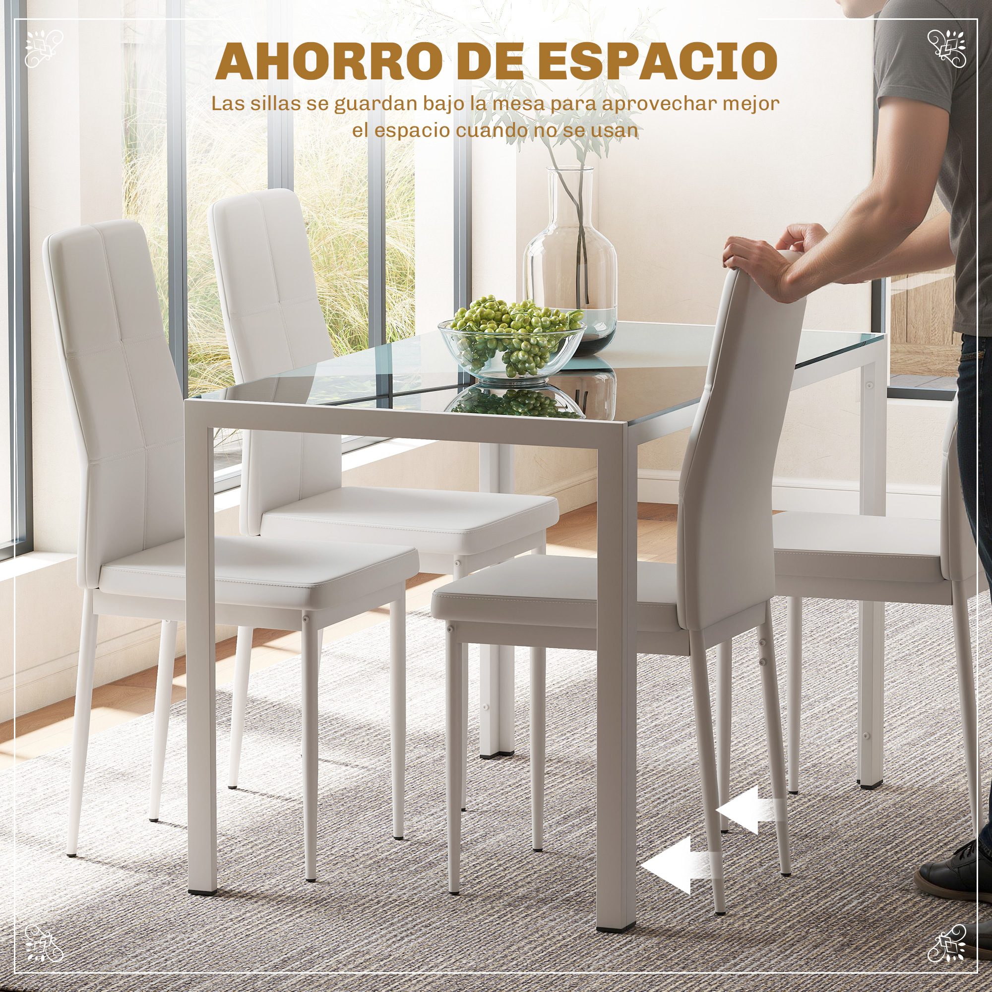 Sillas blancas y mesa de cristal con frutero. Un hombre empuja una silla bajo la mesa.