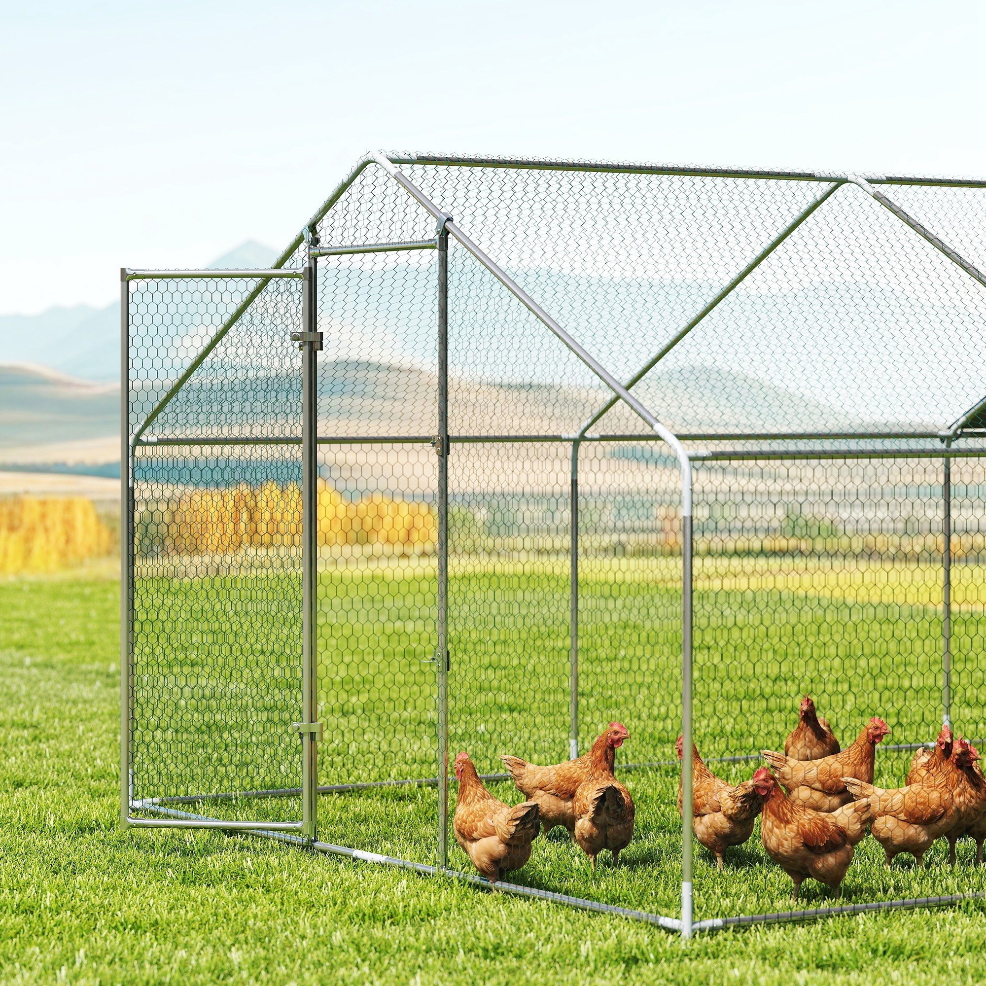 Un gallinero de metal con valla de malla de alambre se encuentra en un campo verde con pollos.