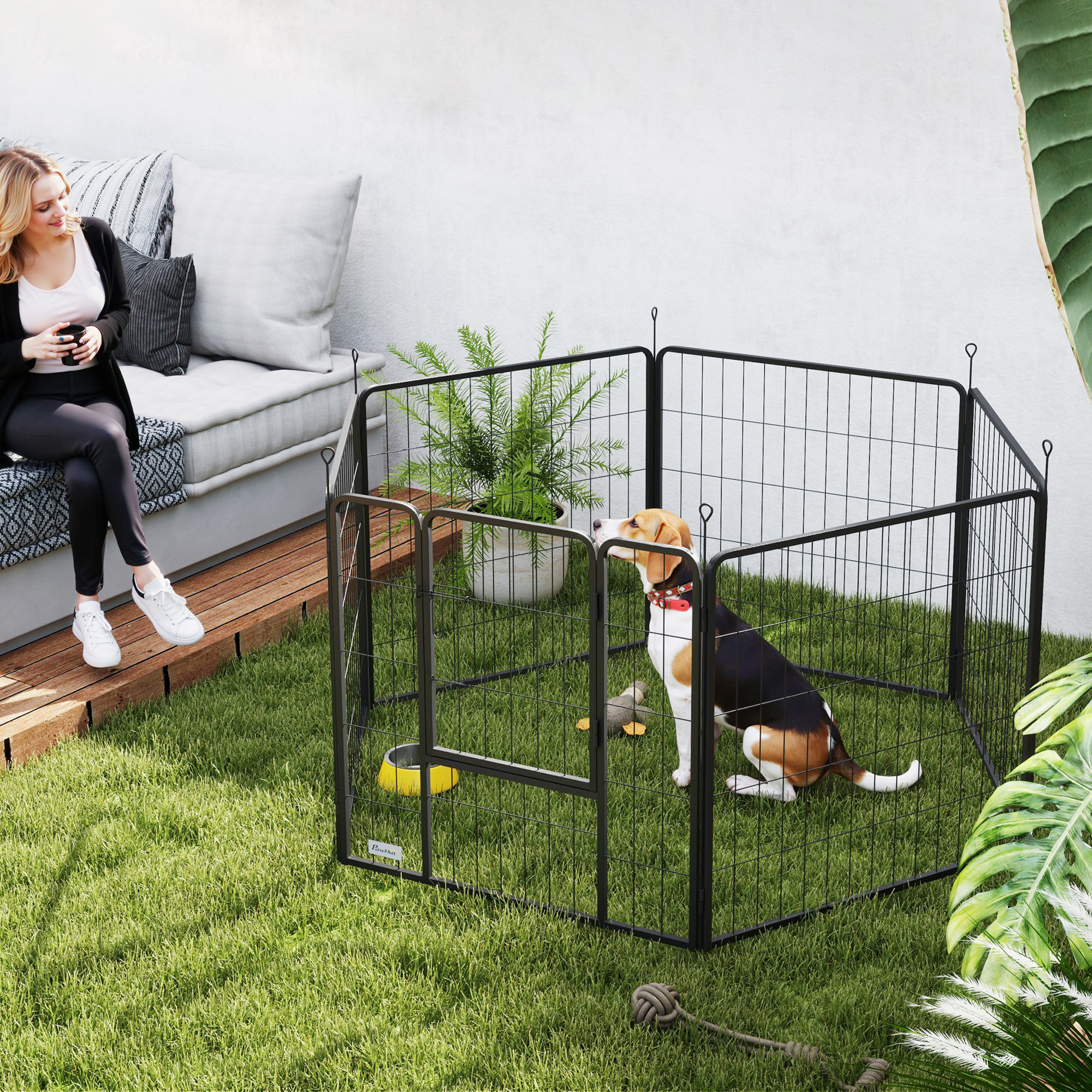 Una mujer sentada en un banco del jardín, un perro en un recinto.