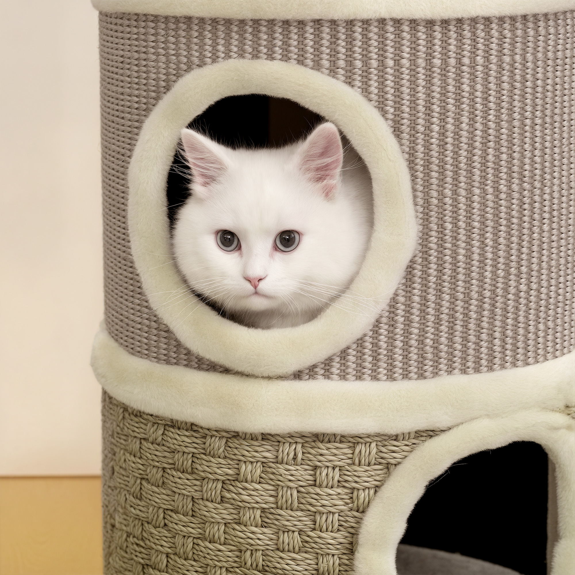 Un gato blanco mira por un agujero en un rascador de varios niveles.