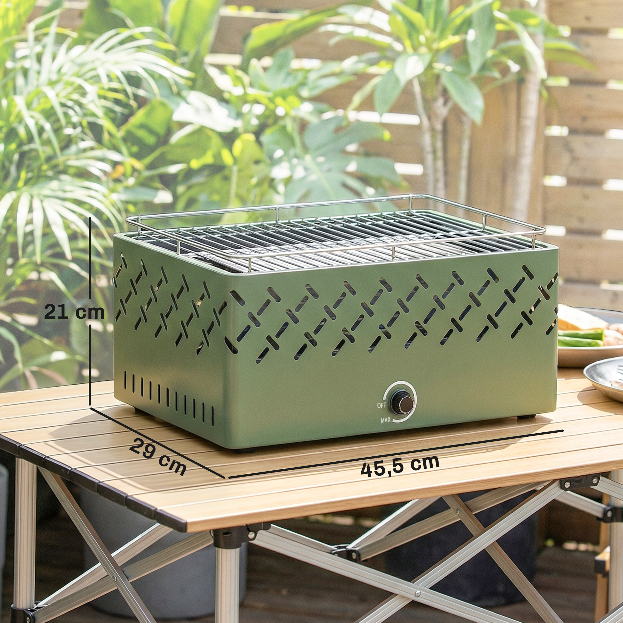 Una parrilla verde sobre una mesa de madera al aire libre con plantas verdes de fondo.