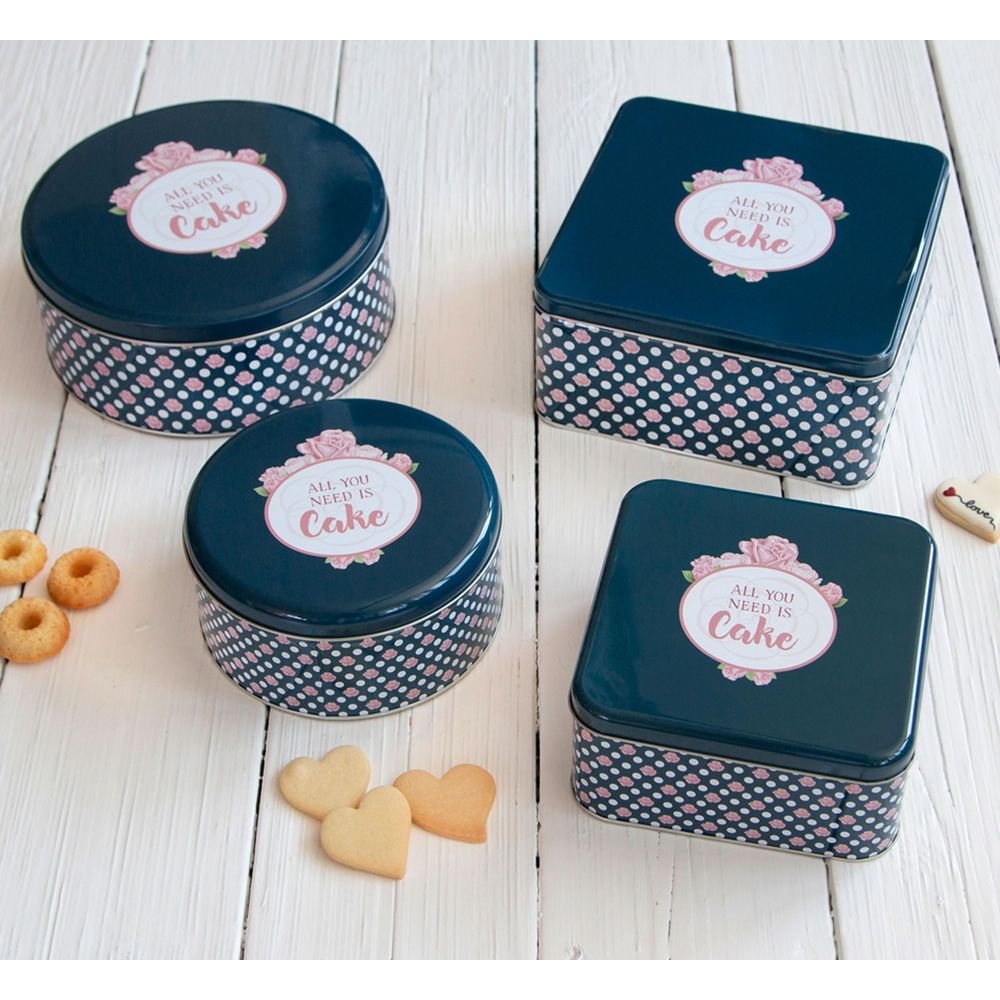Vier dunkelblaue Keksdosen mit rosa Tupfenmuster und Blumenmotiv: 'ALL YOU NEED IS Cake'.