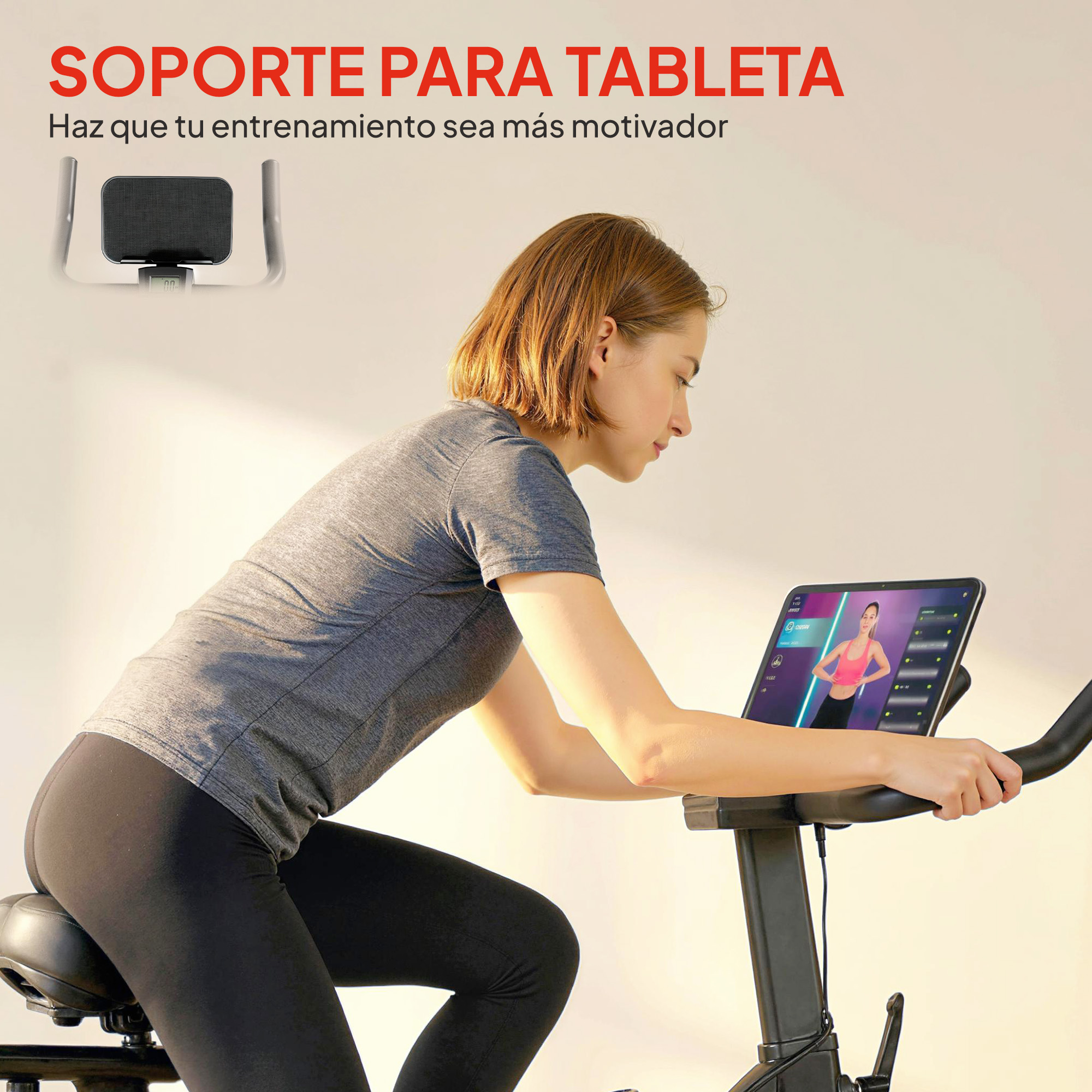 Una mujer se ejercita en una bicicleta estática mirando una tablet con un video de fitness.