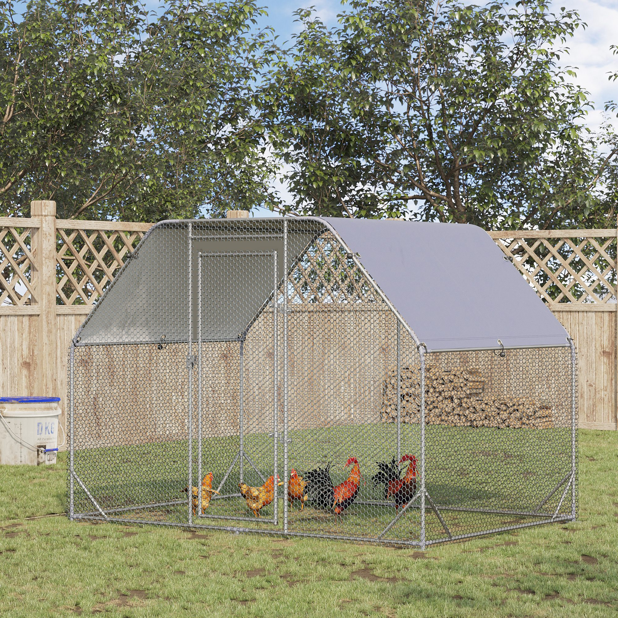 Un gallinero al aire libre con varias gallinas sobre hierba verde.