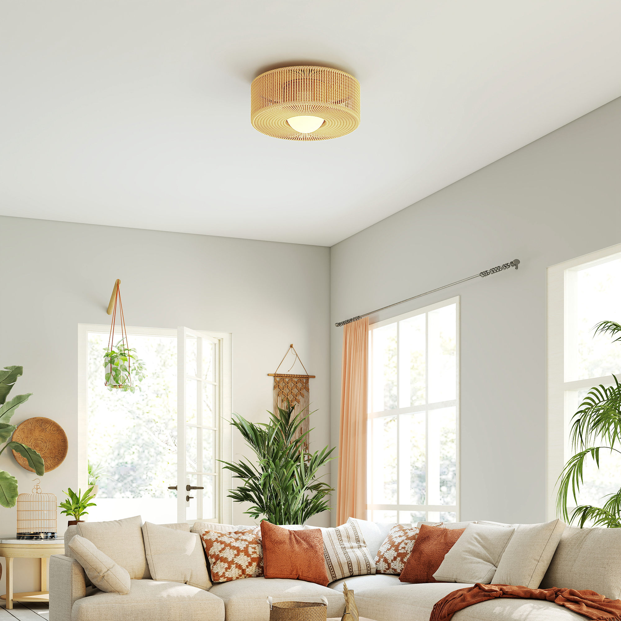 Una sala de estar luminosa con un gran sofá seccional, plantas y luz natural.