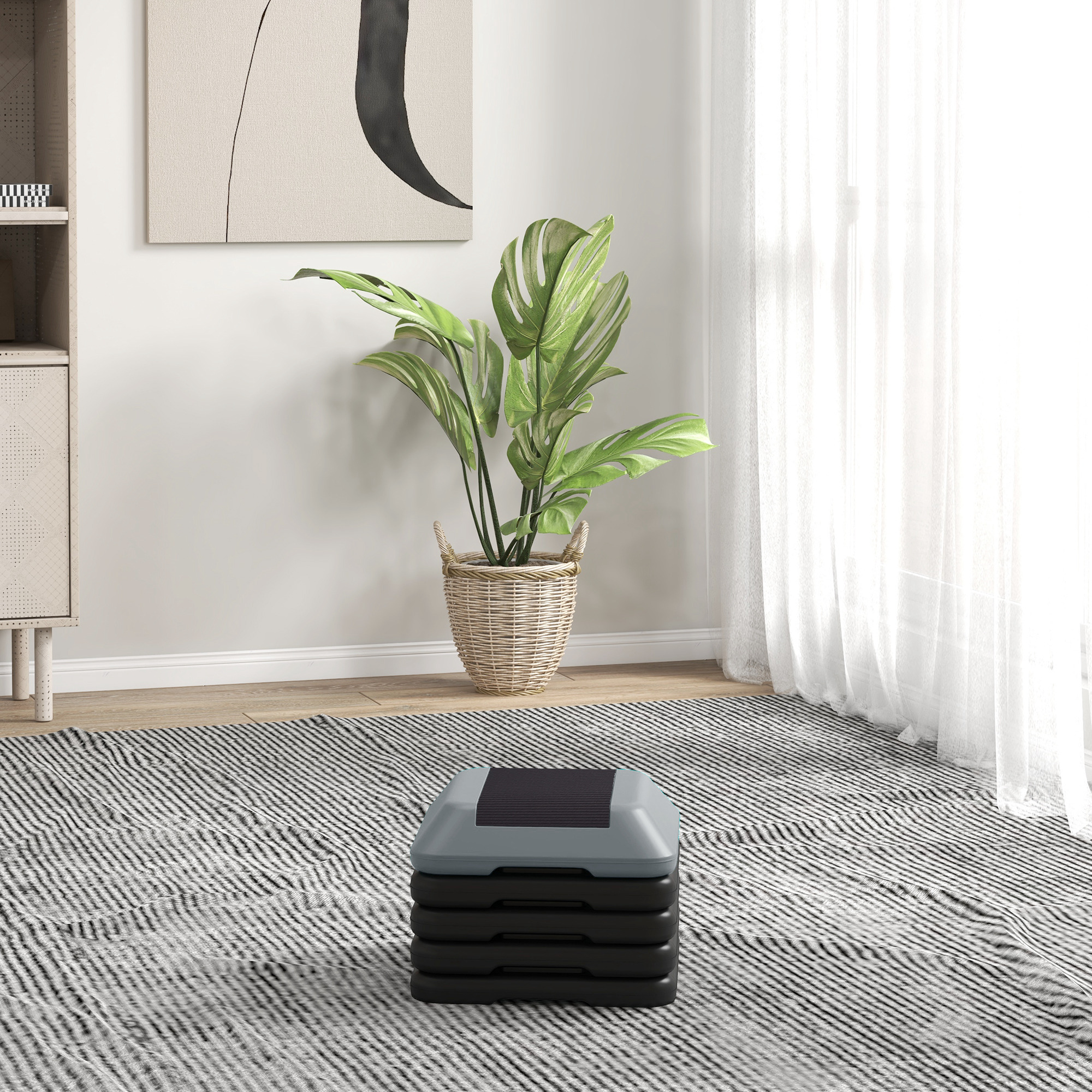 Un stepper de aeróbic gris con superficie superior negra, apilado en cuatro elevadores negros.