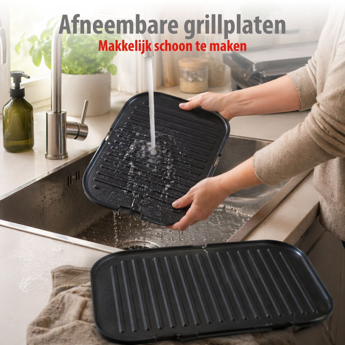 A person cleans grill plates under running water in a sink.