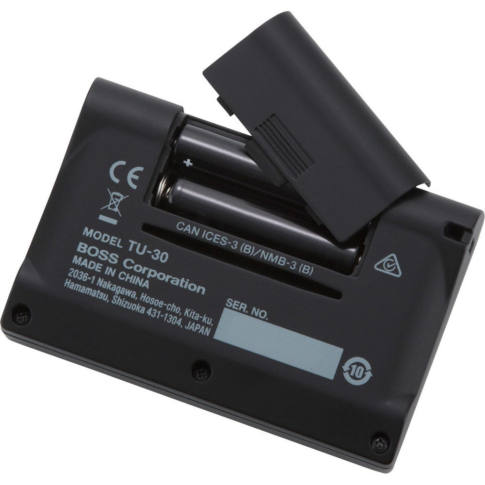 Schwarzer BOSS TU-30 Tuner mit offenem Batteriefach, das 3 AA-Batterien zeigt.