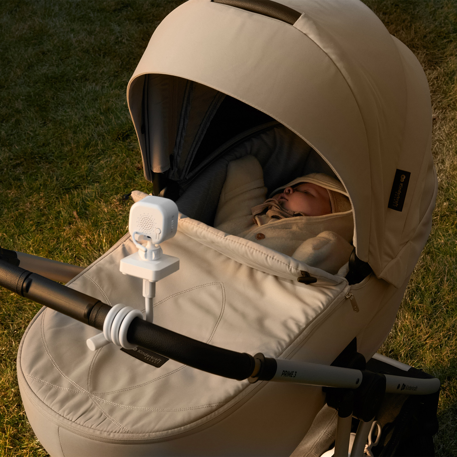 Ein Baby schläft in einem Kinderwagen mit einem Babyfon auf dem Griff.