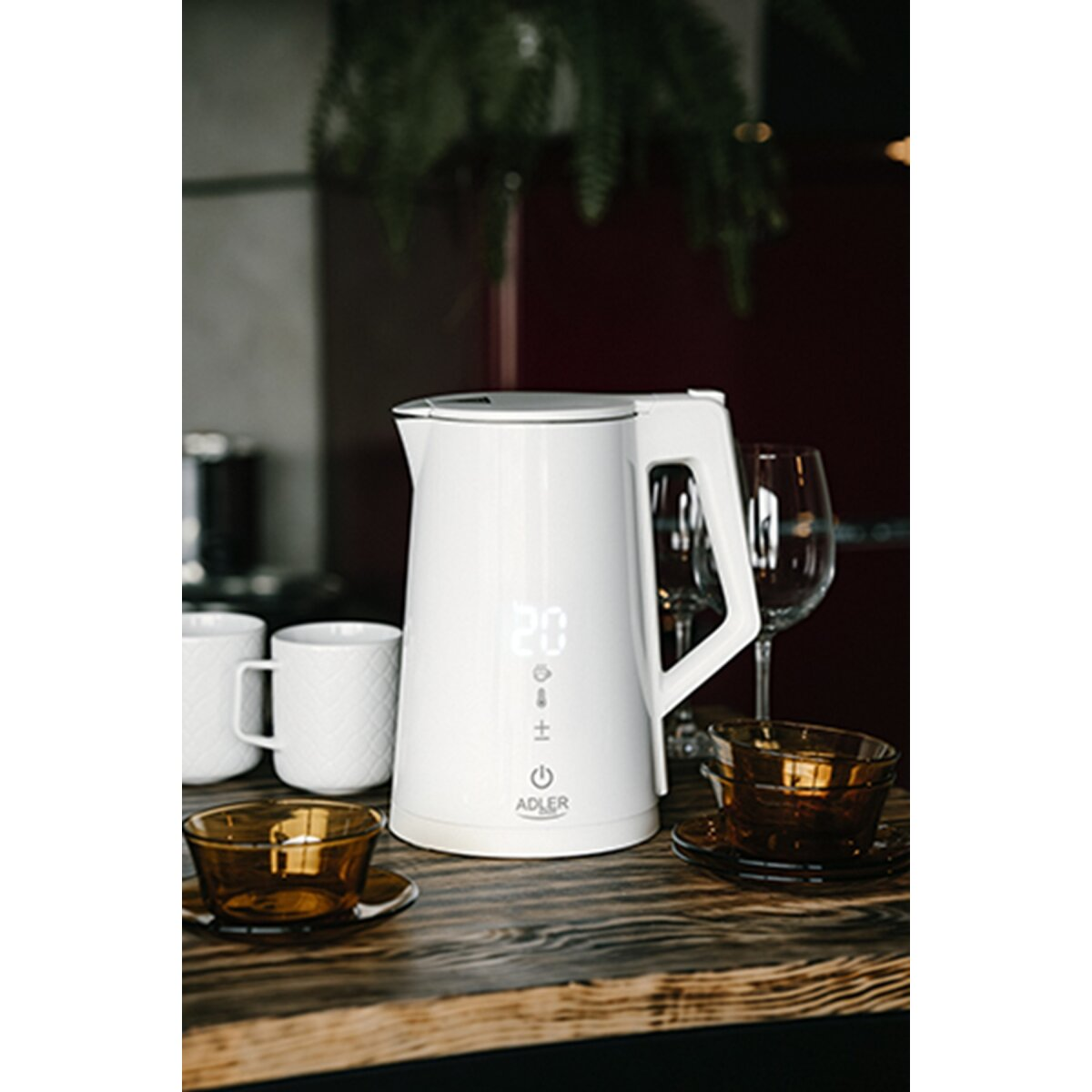 Een witte elektrische waterkoker met digitaal display staat op een houten tafel met kopjes.