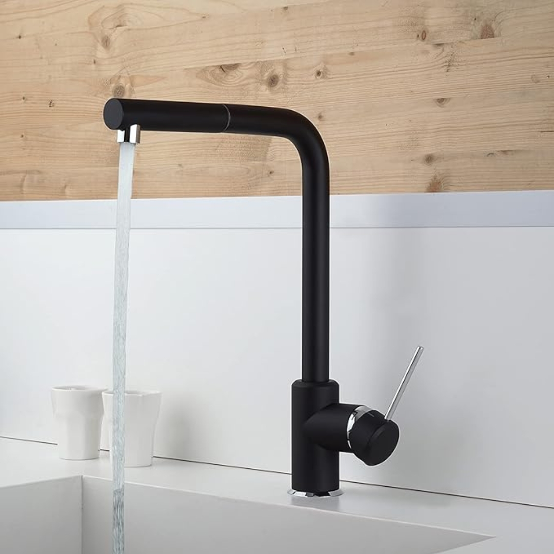 Un rubinetto nero con acqua corrente sopra un lavandino, due tazze bianche accanto.