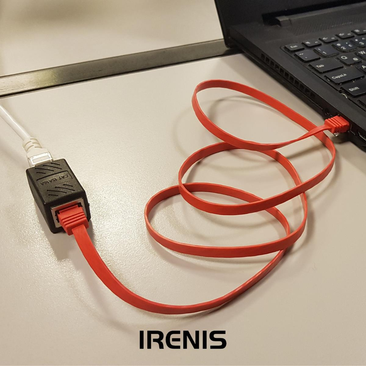 Kırmızı düz Ethernet kablosu, bir dizüstü bilgisayarı siyah bir adaptöre bağlıyor.