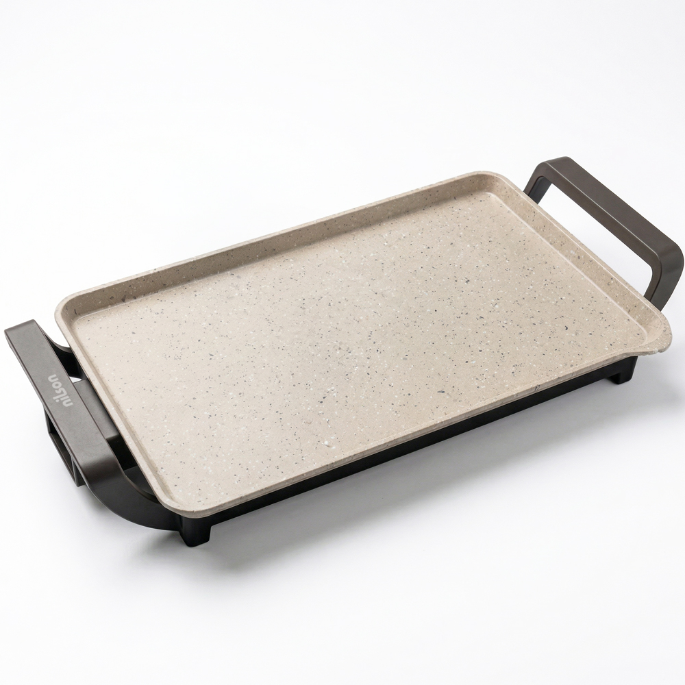 Una plancha eléctrica rectangular y plana con superficie beige claro moteada y asas negras.