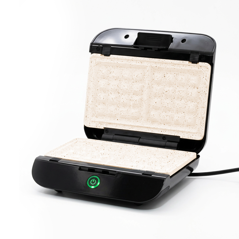 Una sandwichera abierta con placas beige y exterior negro.