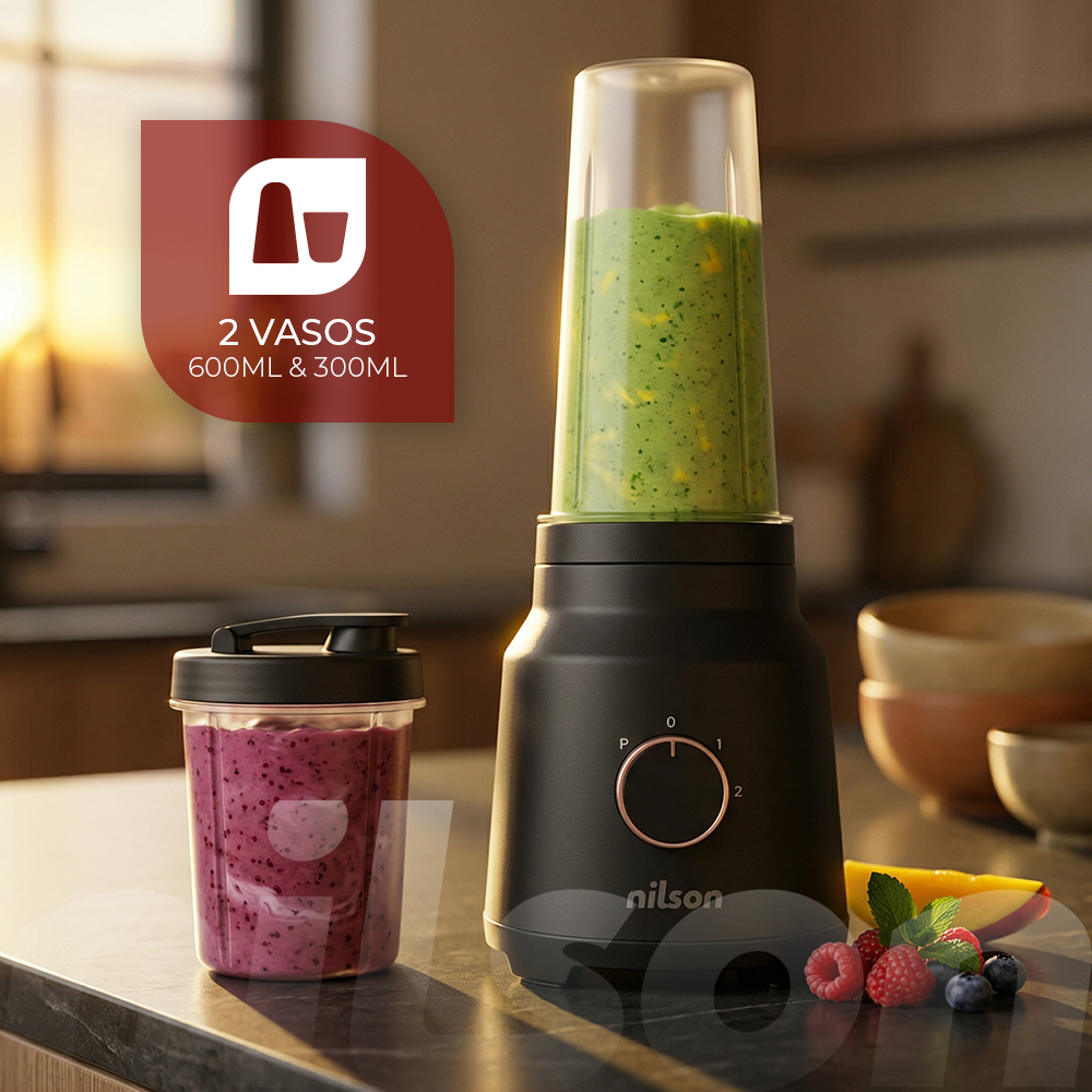Una licuadora negra con dos vasos. Un vaso tiene un batido verde, el otro un batido morado.