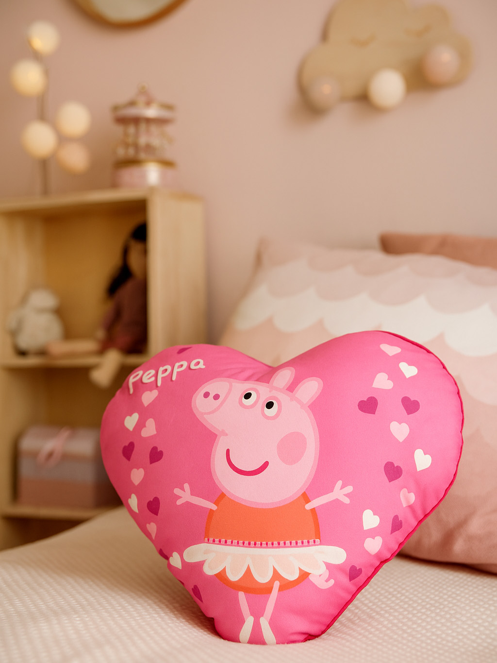 Ein pinkes Herz-Kissen mit Peppa Wutz in einem Tutu, dekoriert mit kleinen Herzen.